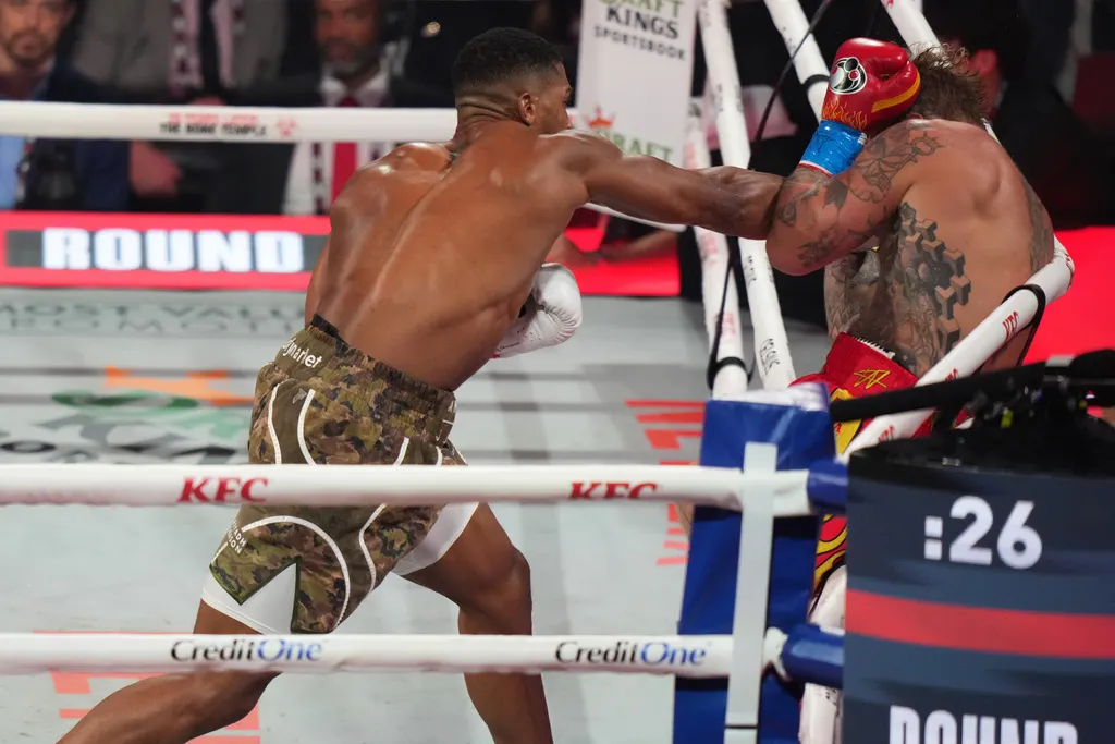 兩屆世界冠軍、奧運金牌約書亞揮拳重擊保羅。（美聯社）