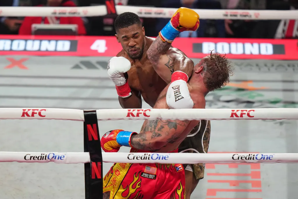 兩屆世界冠軍、奧運金牌約書亞揮拳重擊保羅。（美聯社）