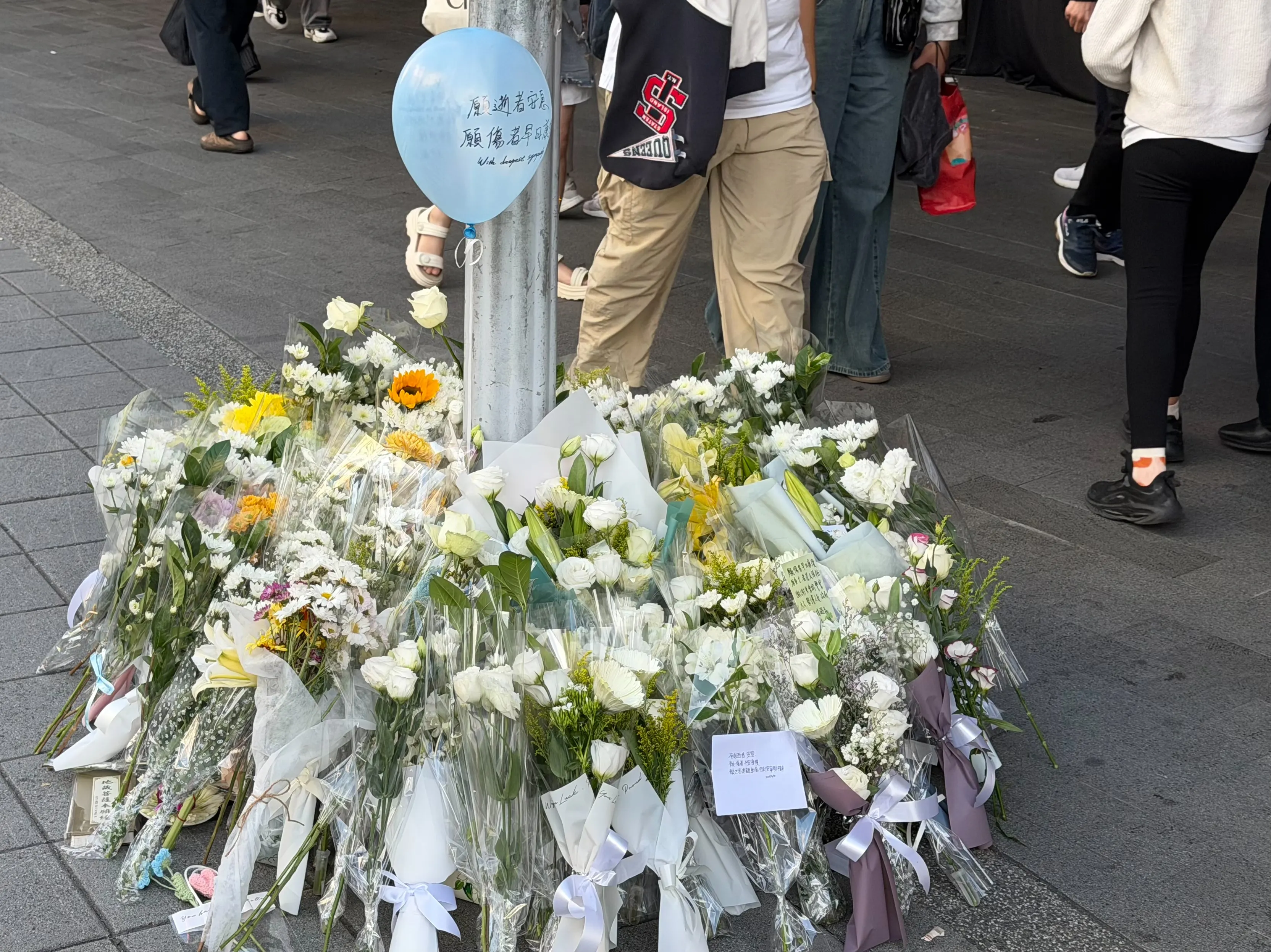 20251220-台北捷運中山站周邊的誠品生活南西店19日晚間遭受歹徒張文無差別攻擊釀死傷，民眾隔天自發性於百貨公司外獻花哀悼。（鍾秉哲攝）