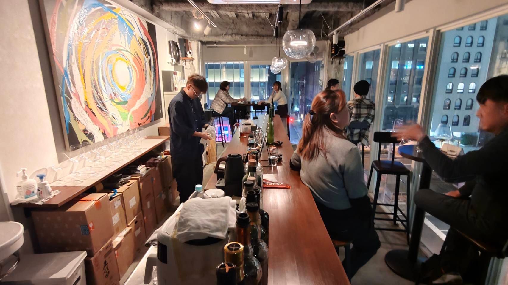 店內僅設五個吧台座位與三張小桌，大片落地窗俯瞰心齋橋繁忙街景，鬧中取靜，侍酒師用中文溝通，讓品酒體驗更到位。（圖/徐炳文攝）