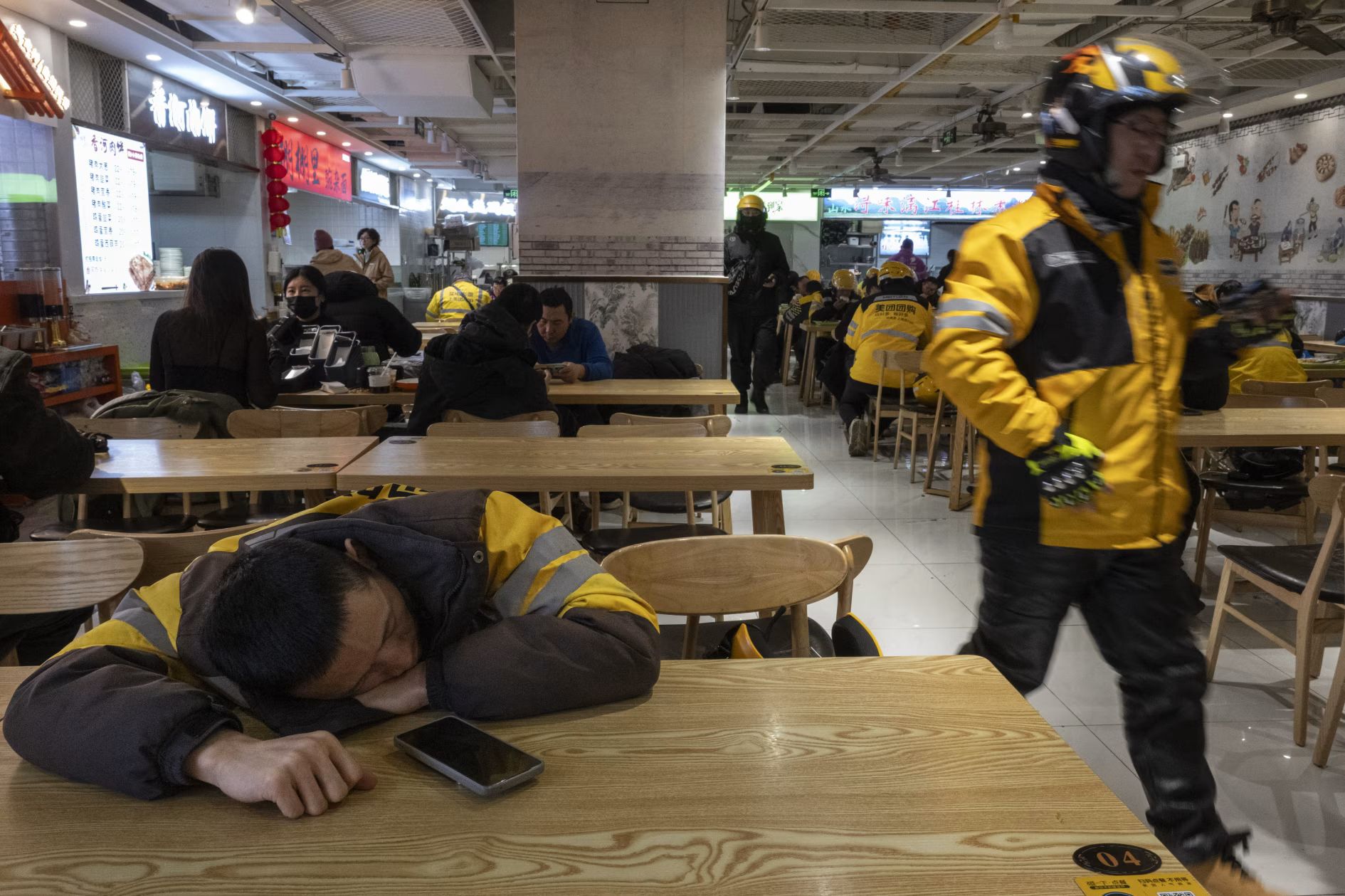 一名外送騎手在午間送餐高峰過後擠出時間小憩片刻。