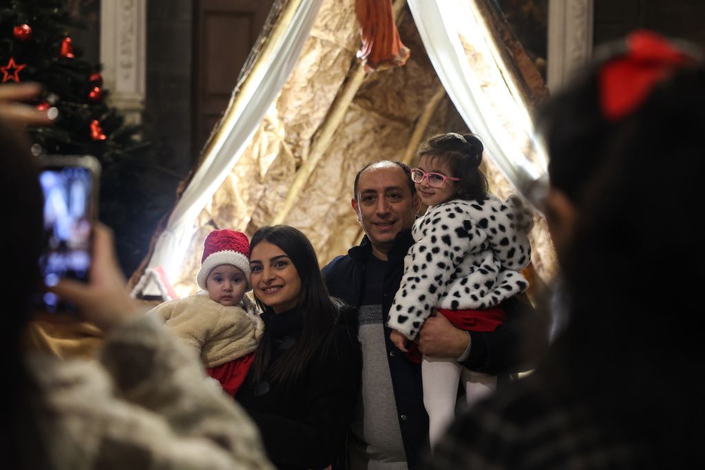 敘利亞基督徒帶著孩子上教堂參加平安夜彌撒。（美聯社）