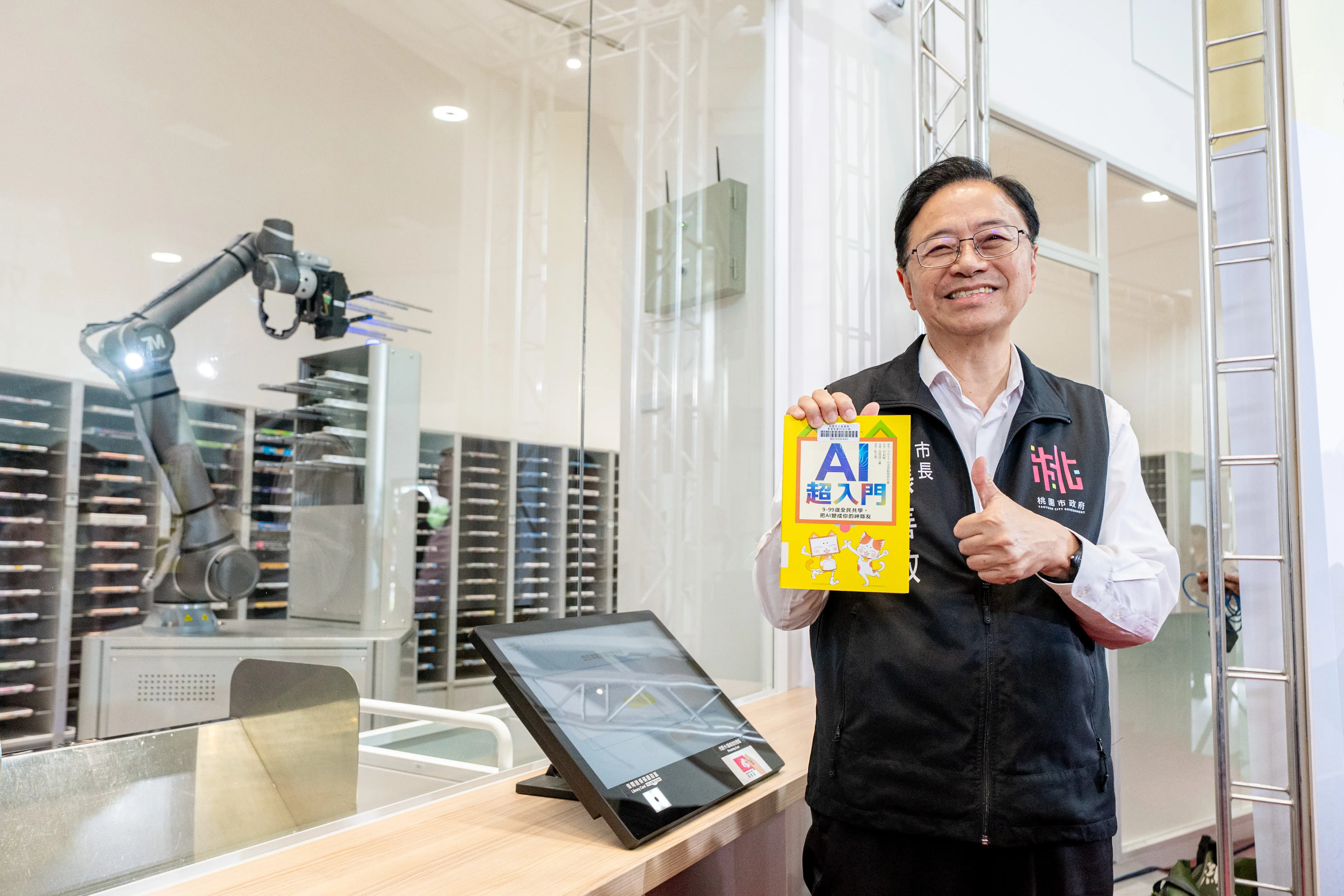桃園市長張善政表示，機器人預約自助取書區，利用機械手臂幫忙取書，智慧又便利。(圖／桃園市政府提供)
