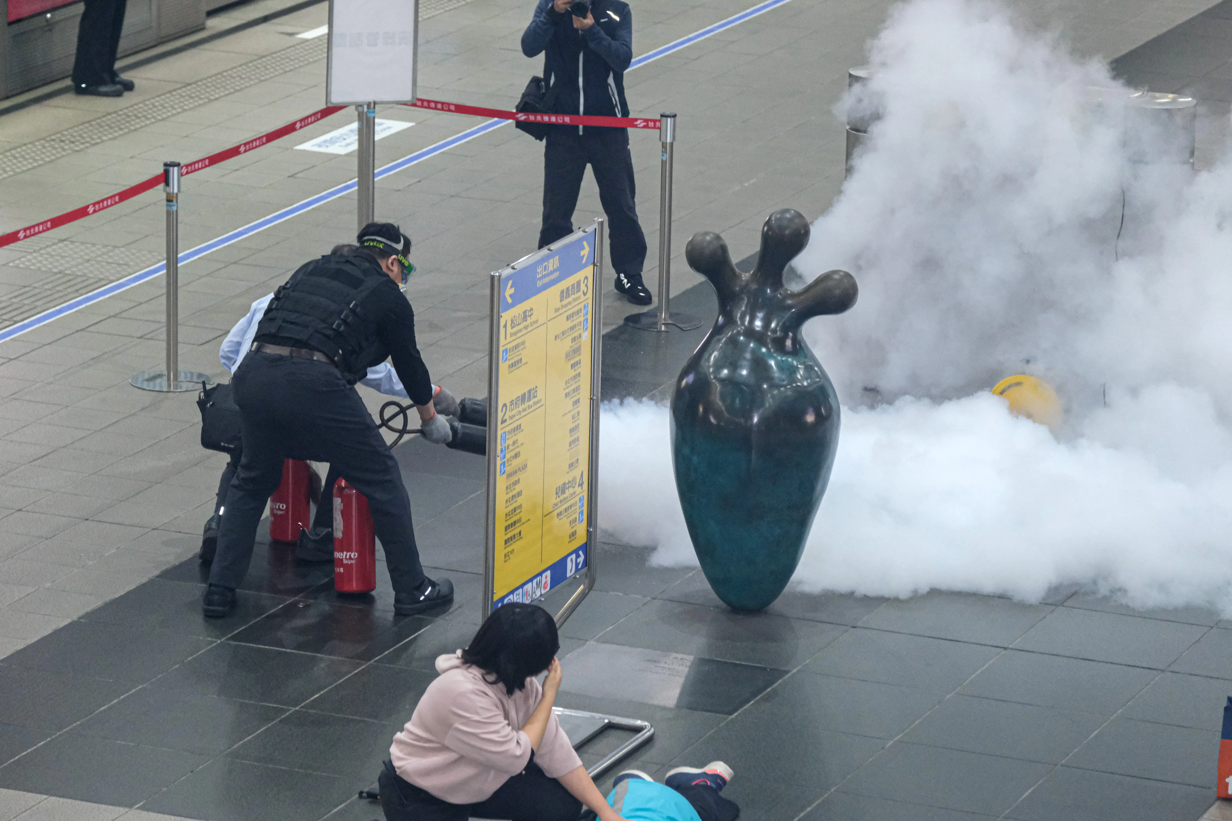 20251226-台北市政府26日於捷運市政府站進行捷運危安事件實兵演練，圖為歹徒於捷運月台層丟擲汽油彈之應變處置。（劉偉宏攝）
