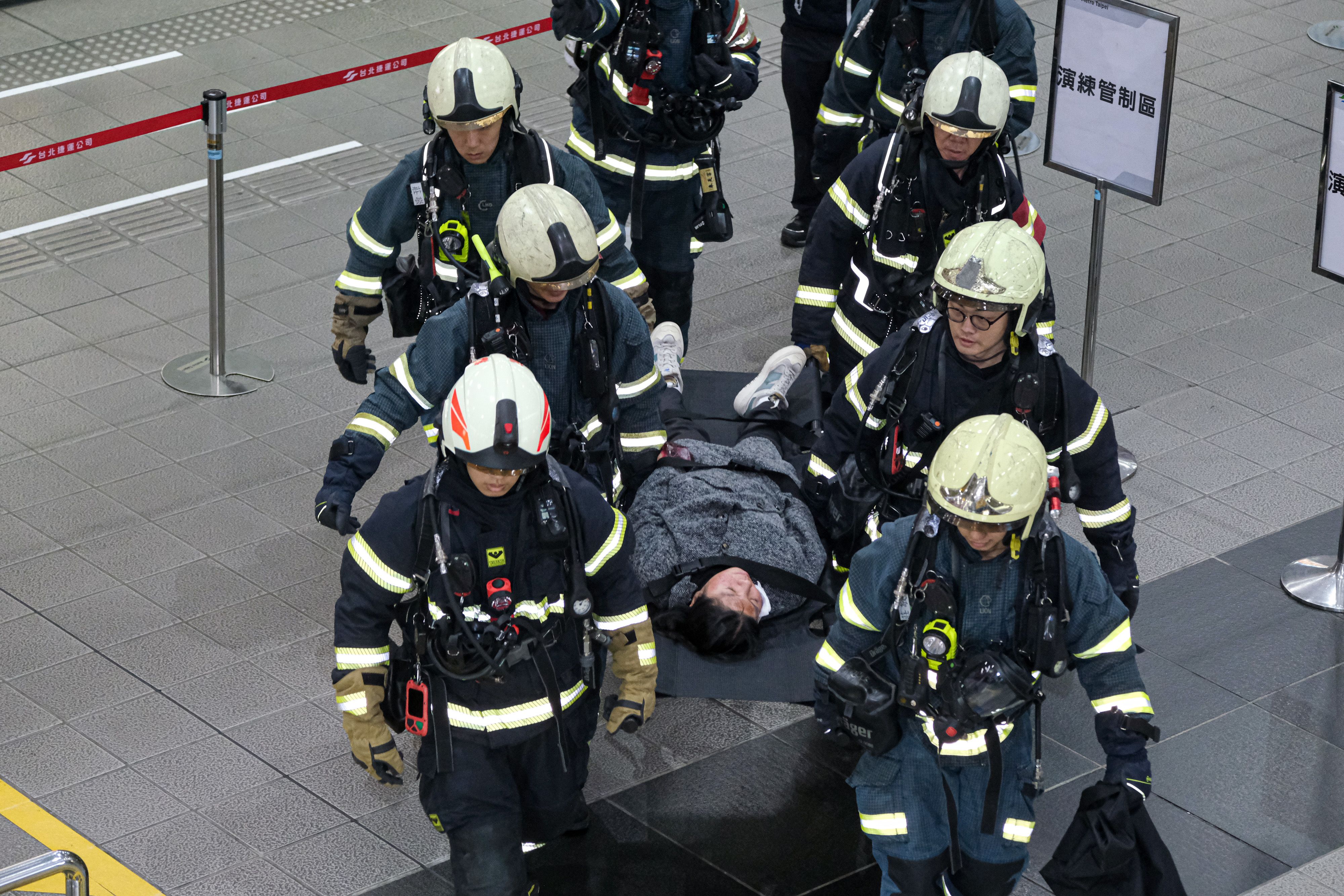 20251226-台北市政府26日於捷運市政府站進行捷運危安事件實兵演練，圖為消防用擔架移動傷員的演練情形。（劉偉宏攝）