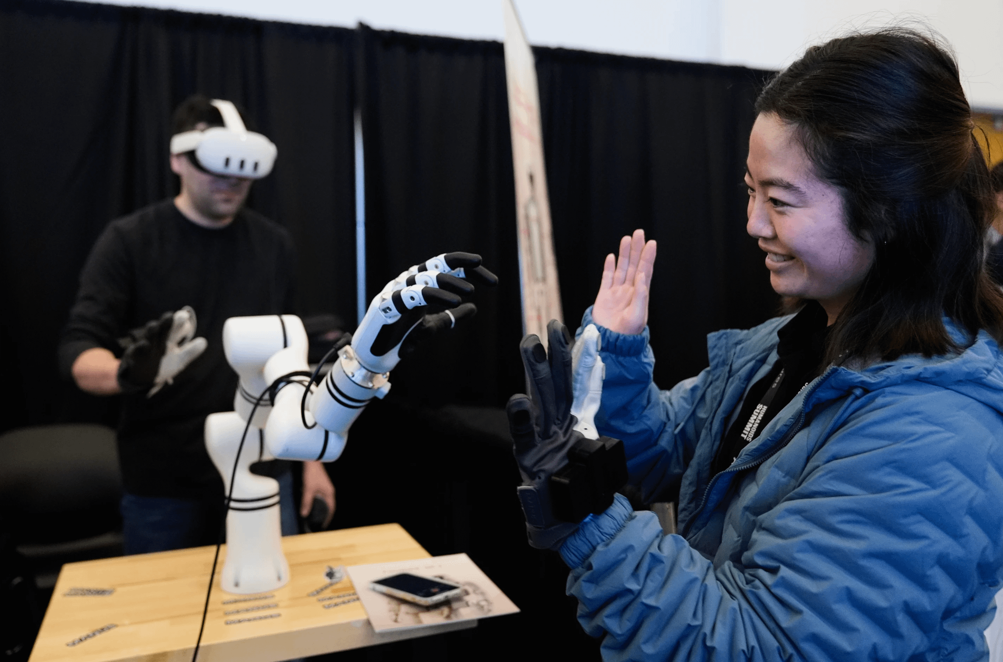 2025年12月11日，在加州山景城舉行的人形機器人高峰會上，一名女子在展場內與機器人互動。 （美聯社）