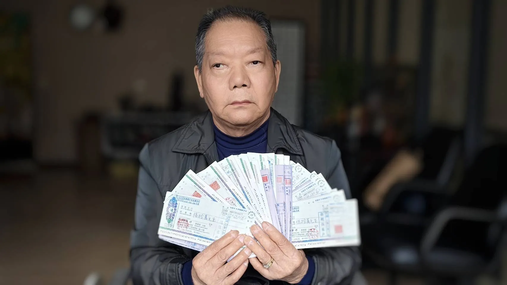 施姓債權金主手持40張陳玫娟跳票2千多萬拒往的支票，質疑陳與其林姓女助理聯手運作借貸。（圖/徐炳文攝）