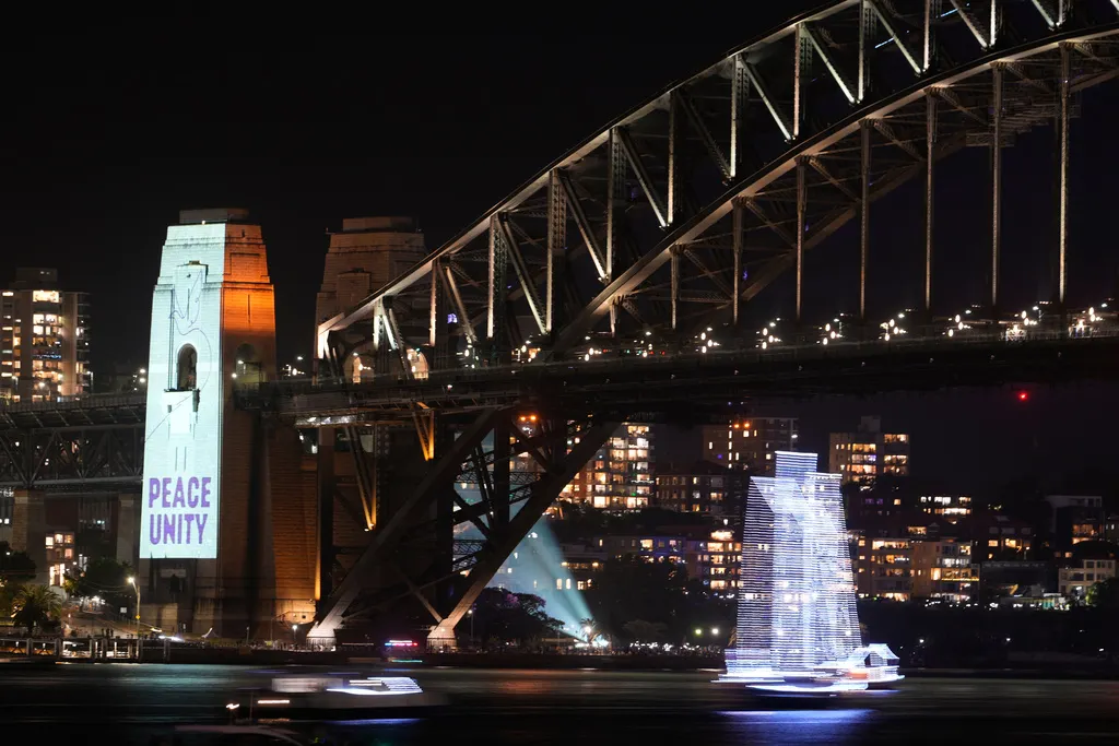 澳洲雪梨迎接2026的跨年煙火秀，同時還用燈光打上「和平團結」。（美聯社）