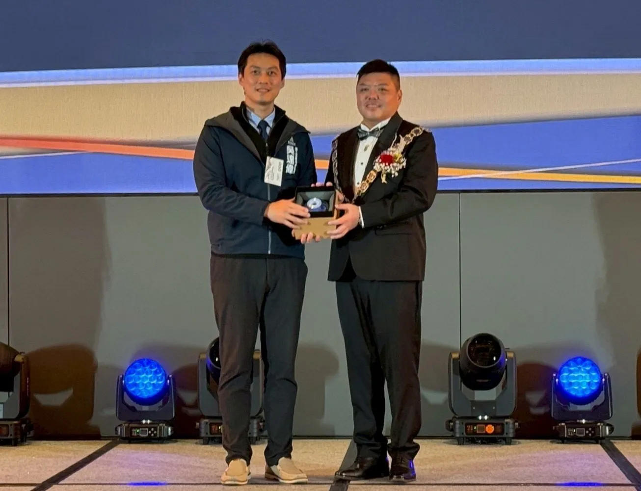 竹市勞青處長吳達偉（左）代表市府致贈新任青商總會長張旭志玻璃藝品賀禮。（圖／新竹市政府提供）