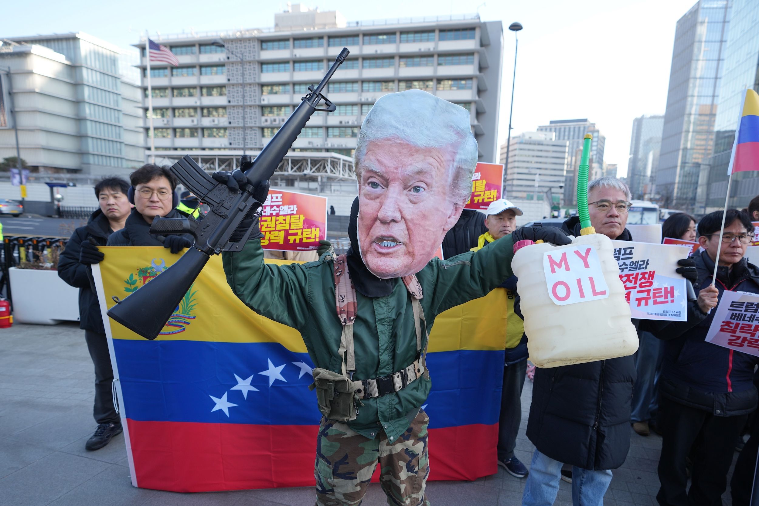 2026年1月5日，在韓國首爾美國大使館附近，一名戴著川普面具的男子手持玩具槍，參加譴責美國政府和川普的集會。（美聯社）