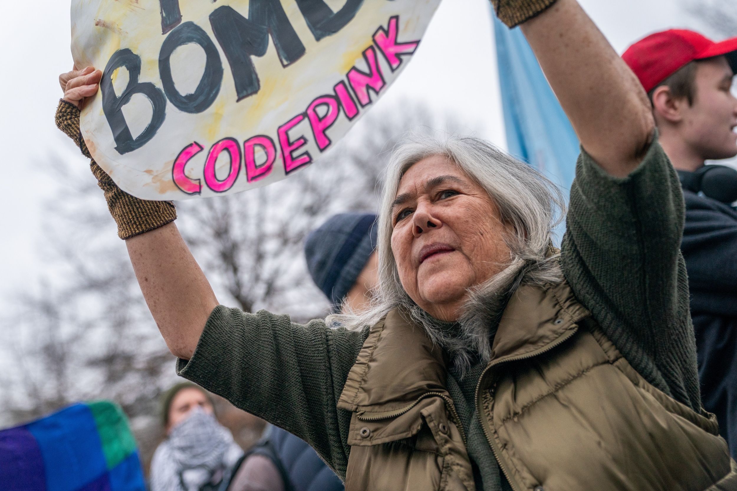 2026年1月6日，美國華府，一名示威者在約翰・F・甘迺迪表演藝術中心外的集會上手持抗議標語，要求結束美國對委內瑞拉的干預。（美聯社）