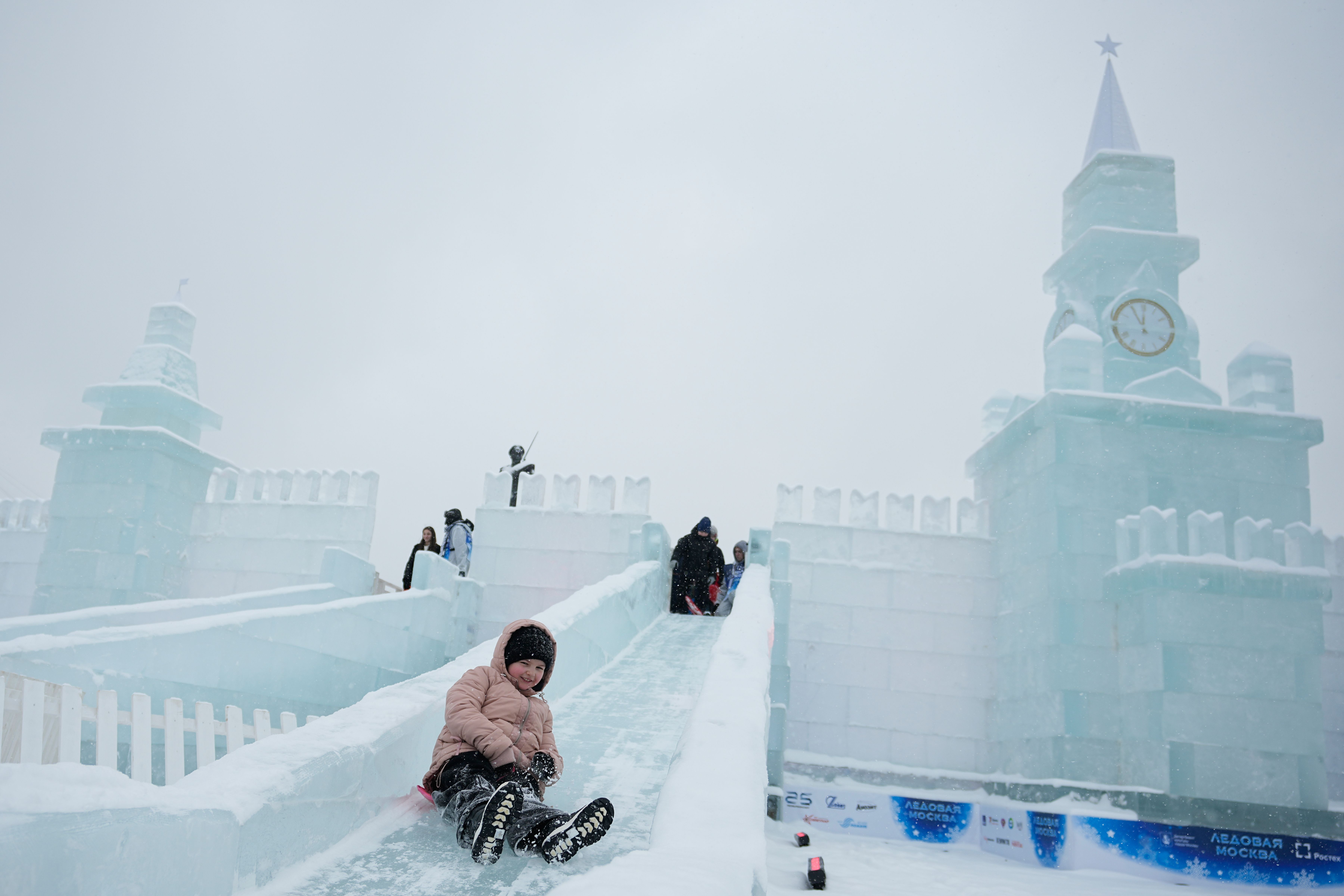 2025年12月30日，俄羅斯莫斯，一名男孩在勝利公園（Victory Park）舉辦的「冰雪莫斯科」（Icy Moscow）節慶活動中，從一座仿造克里姆林宮造型的冰滑梯歡樂溜下。（美聯社）