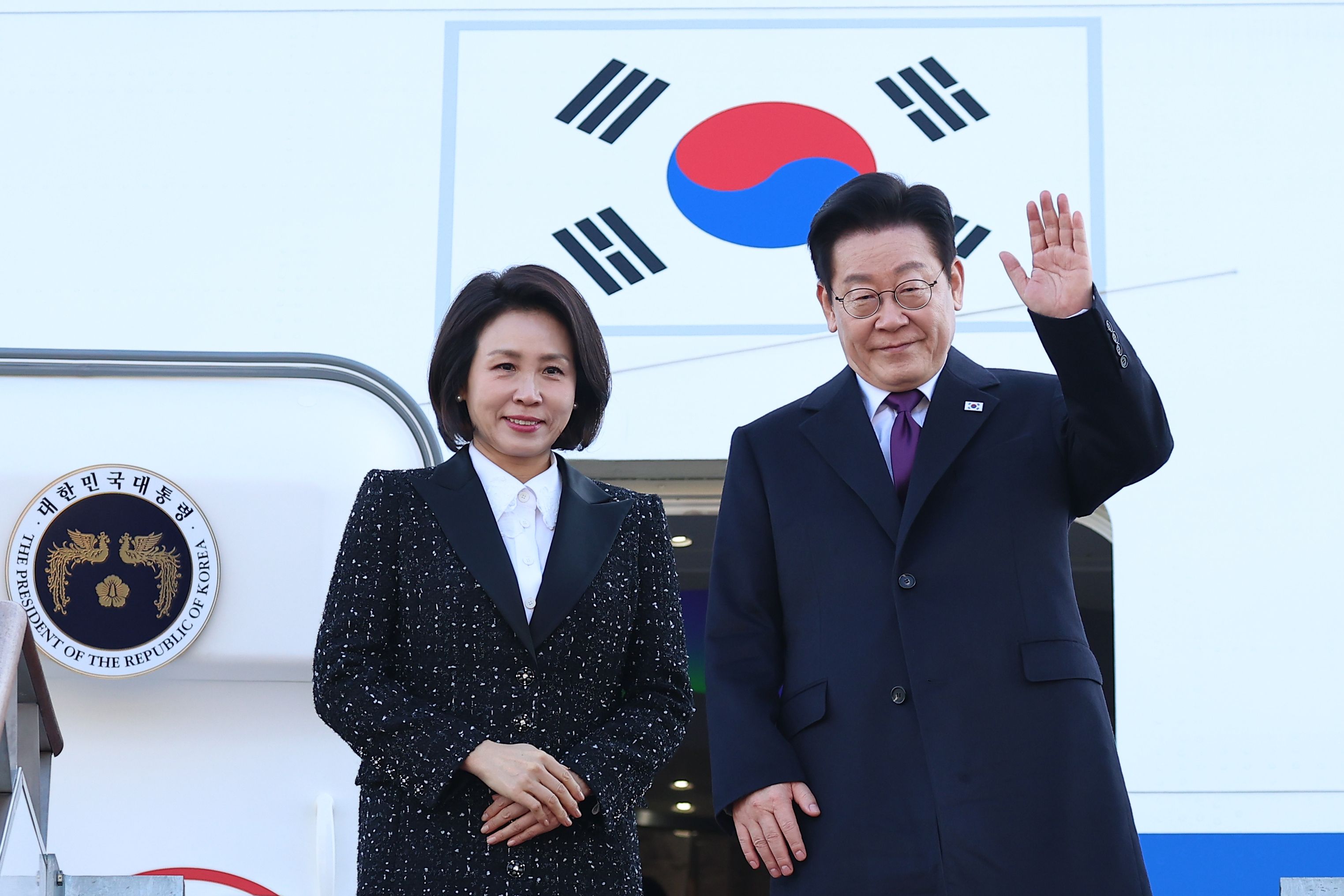 2026年1月13日，韓國總統李在明和夫人金惠景在首爾機場揮手告別，準備前往日本。（美聯社）