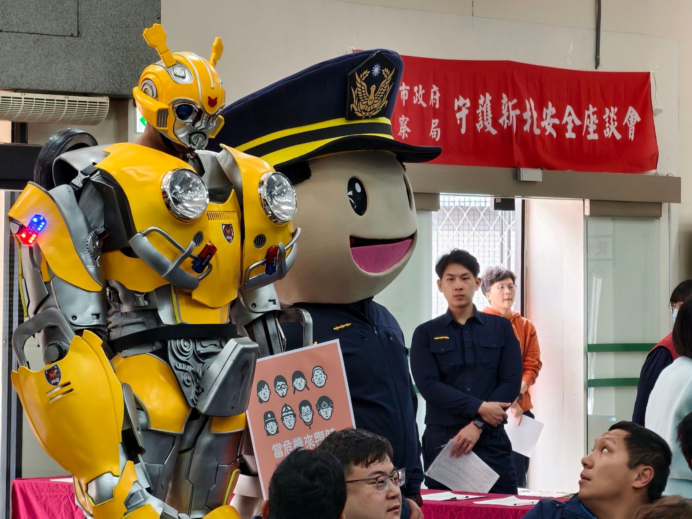 象徵守護力量的「變形金剛大黃蜂」手持「小橘書」現身會場，成為宣導焦點，也讓全民安全指引真正走進民眾視線。（圖/新北政府警察局中和分局提供）