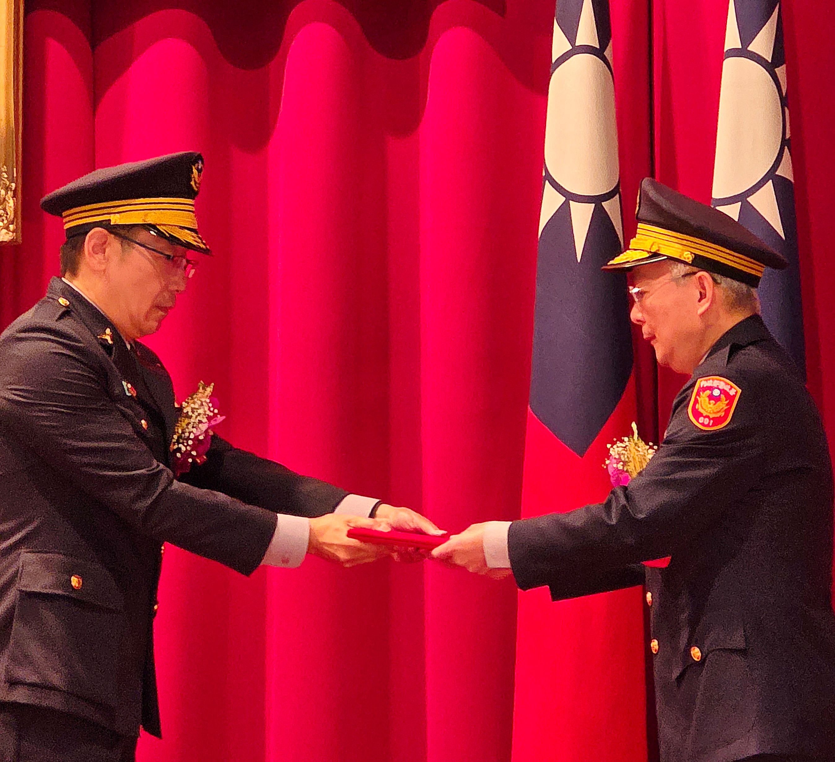 刑事警察局卸新任局長交接典禮中，警政署署長張榮興(右)將象徵職權的交接文件親自交付新任局長邱紹洲，宣告刑事局權力核心完成交棒，打詐與偵防主戰責任正式移轉。(照片/蔡上機提供 鄧亦涵翻拍)