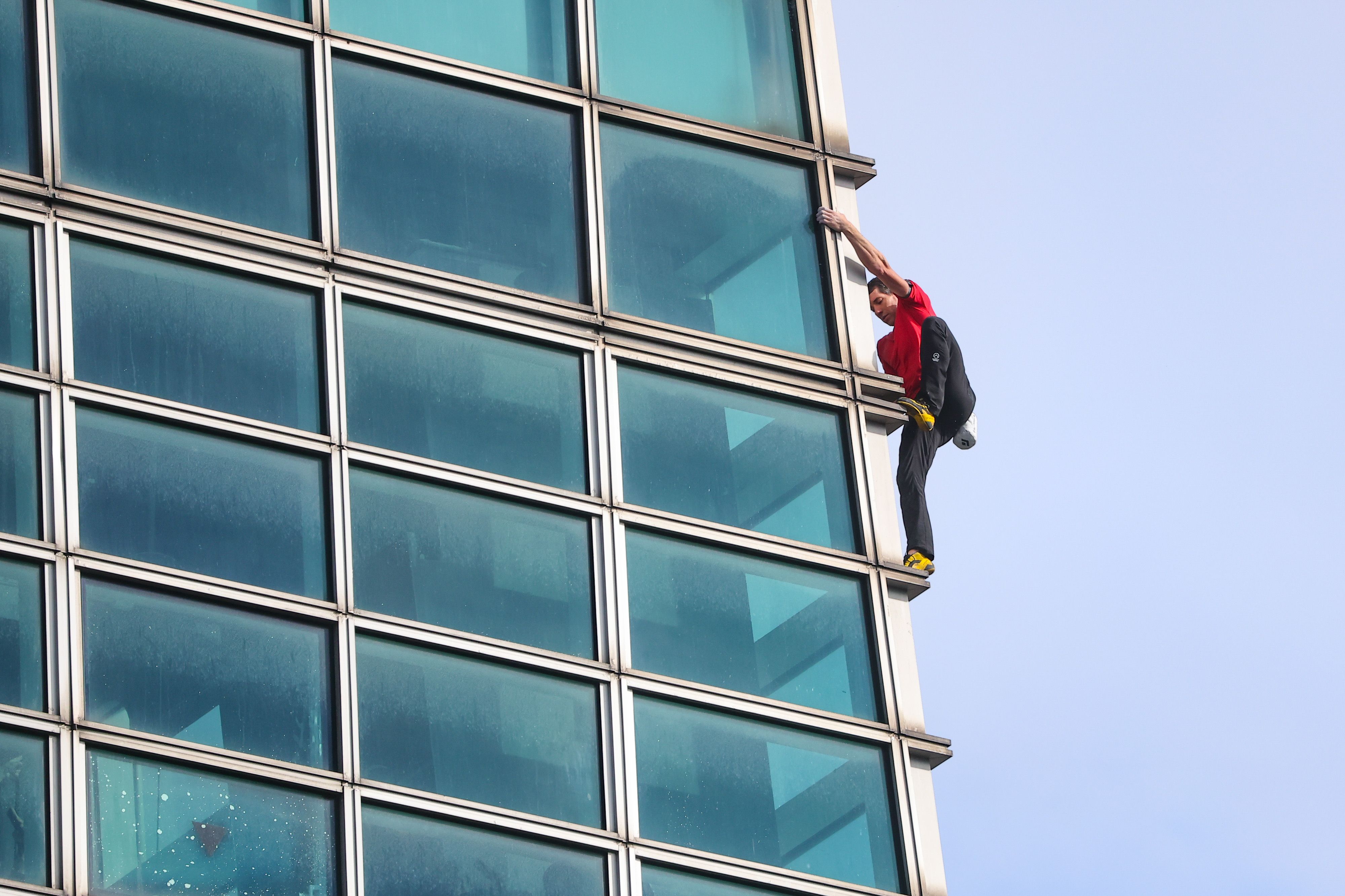 20260125-艾力克斯・霍諾德（Alex Honnold，紅衣者）25日徒手攀登台北 101大樓。（顏麟宇攝）