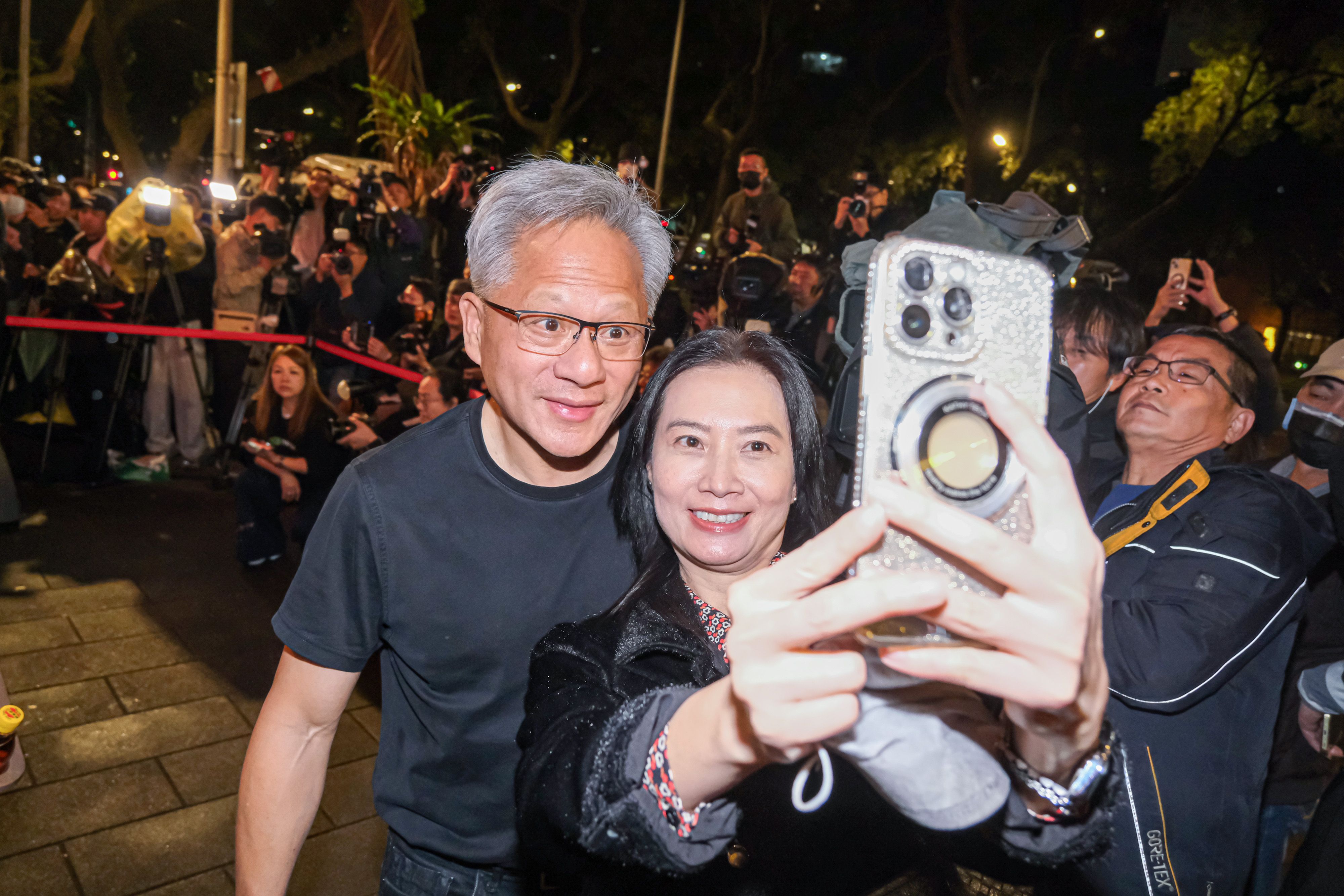 20260131-輝達創辦人暨董事長黃仁勳（左）31日赴磚窯古早味懷舊餐廳出席「兆元宴」，並熱情與現場粉絲合照。（劉偉宏攝）