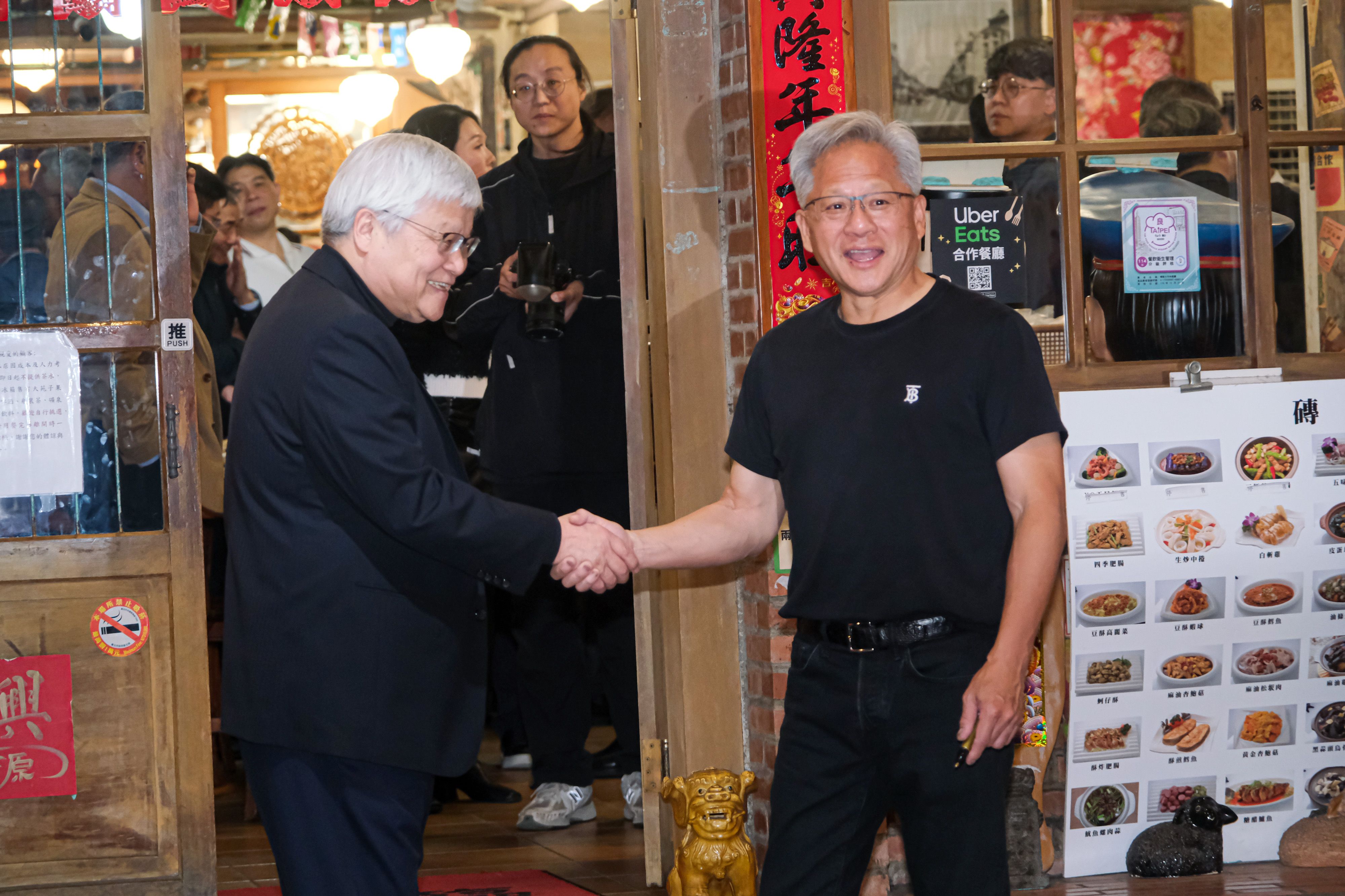 20260131-輝達創辦人暨董事長黃仁勳（右）、台積電董事長魏哲家（左）31日赴磚窯古早味懷舊餐廳出席「兆元宴」，並於離開前進行握手合照。（劉偉宏攝）