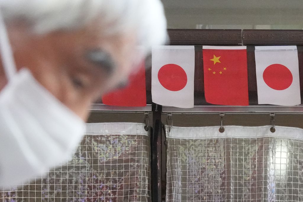 日本橫濱中華街路邊懸掛日中兩國國旗。（美聯社）