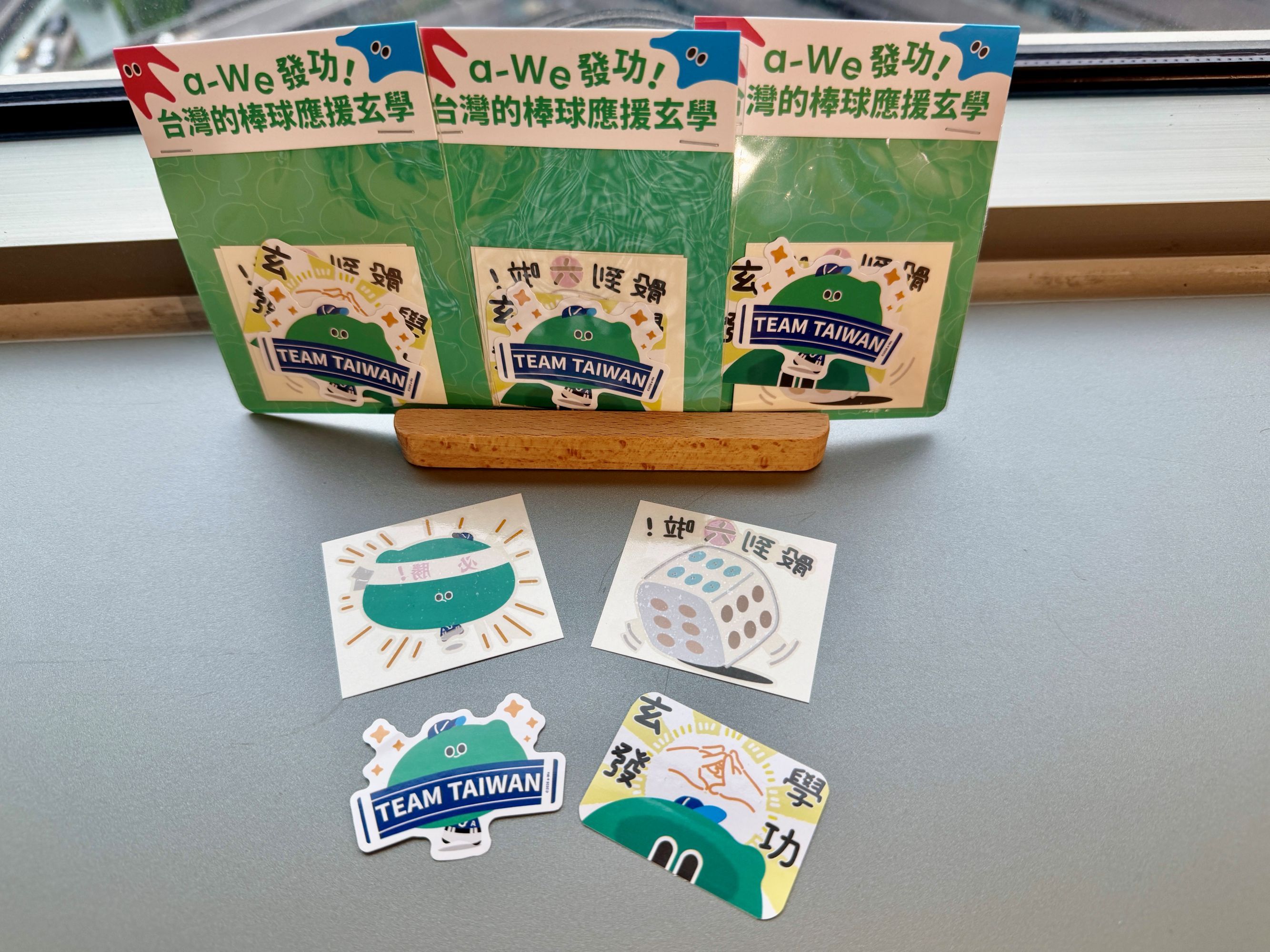 「a-We」限量「應援貼紙包」，內含「TEAM TAIWAN」、「玄學發功」造型貼紙，以及充滿鬥志的「必勝」、「骰到六啦！」紋身貼紙。（圖／文化部提供）