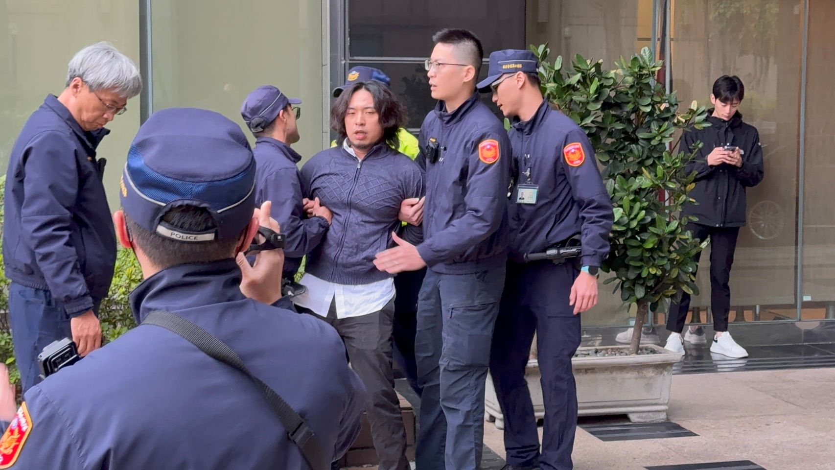 不明男子闖入議場旁邊的研究大樓，不斷辱罵員警三字經，最終被警方壓制。（張曜麟攝）