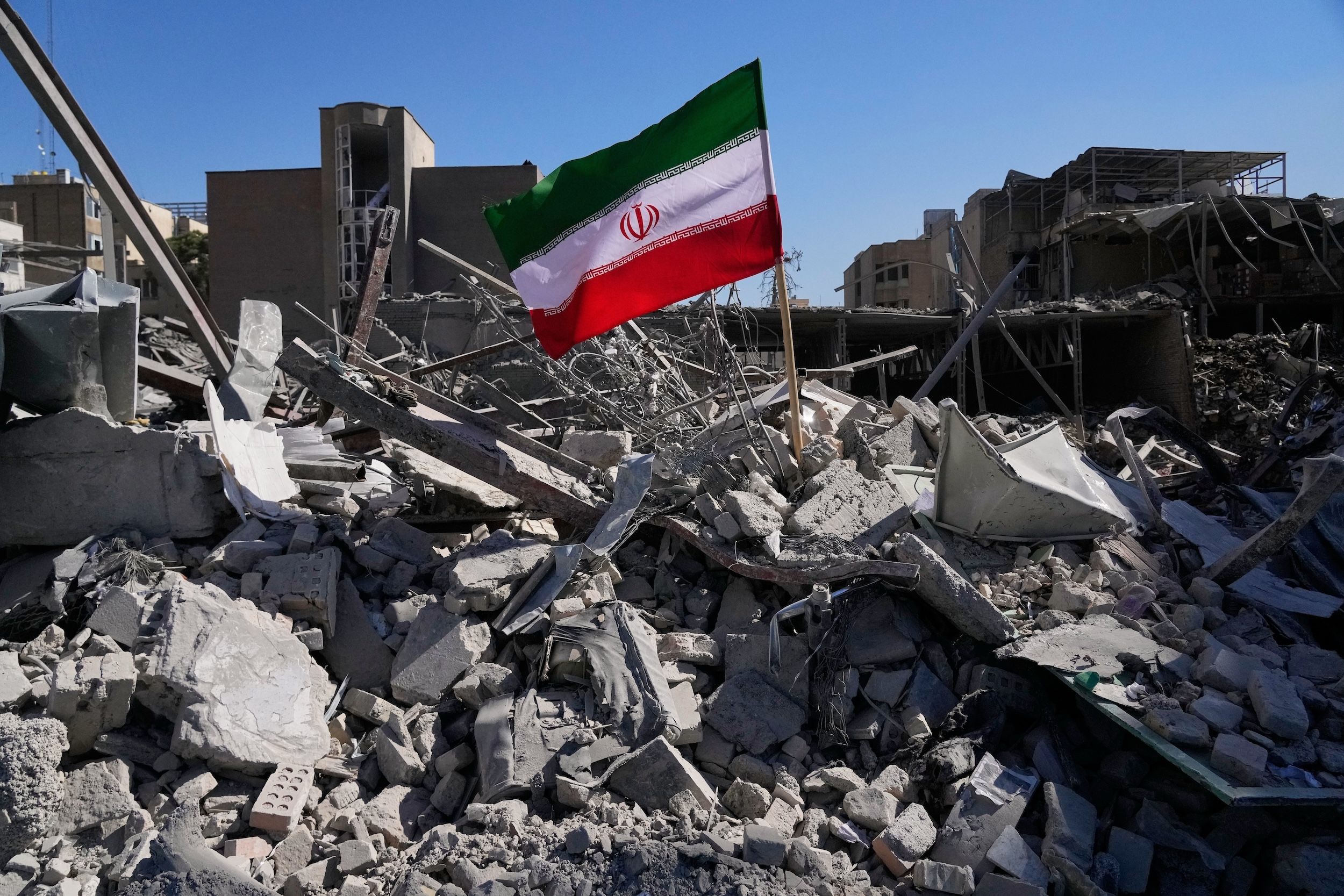 2026年3月3日，伊朗德黑蘭，在美以軍事行動擊中一處警察局後，一面伊朗國旗被放置在廢墟之中。（美聯社）