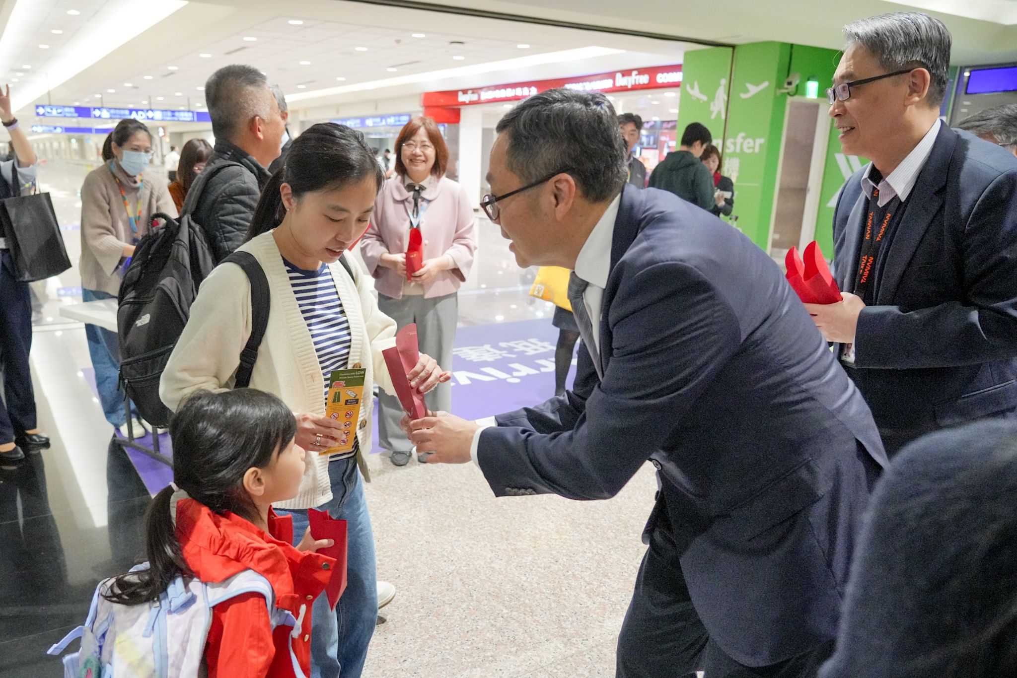 20260305-外交部政務次長陳明祺5日下午親自到桃園國際機場迎接自阿拉伯聯合大公國杜拜返抵台灣的國人，並發放裝有蘋果酥的紅包表達慰問。（外交部提供）