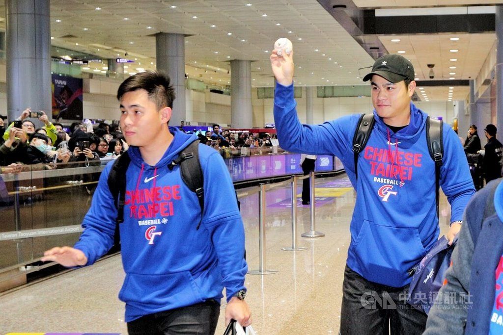 中華隊11日凌晨搭機抵台，第二航廈接機大廳更湧入逾300名球迷以行動力挺台灣隊，球員宋晟睿（右）也向球迷展示棒球，球迷直呼「是接殺韓國的最後一顆球」。（取自中央社）
