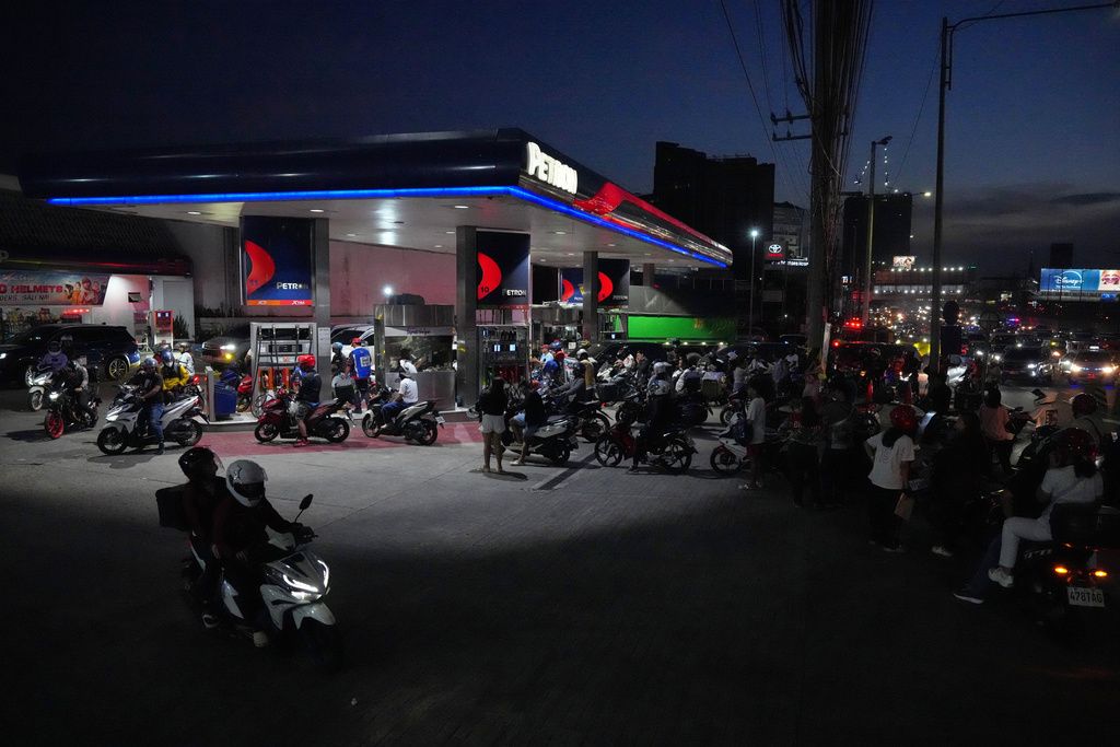 大批摩托車湧入菲律賓奎松市一處加油站，希望搶在出缺前提前加滿備存。（美聯社）