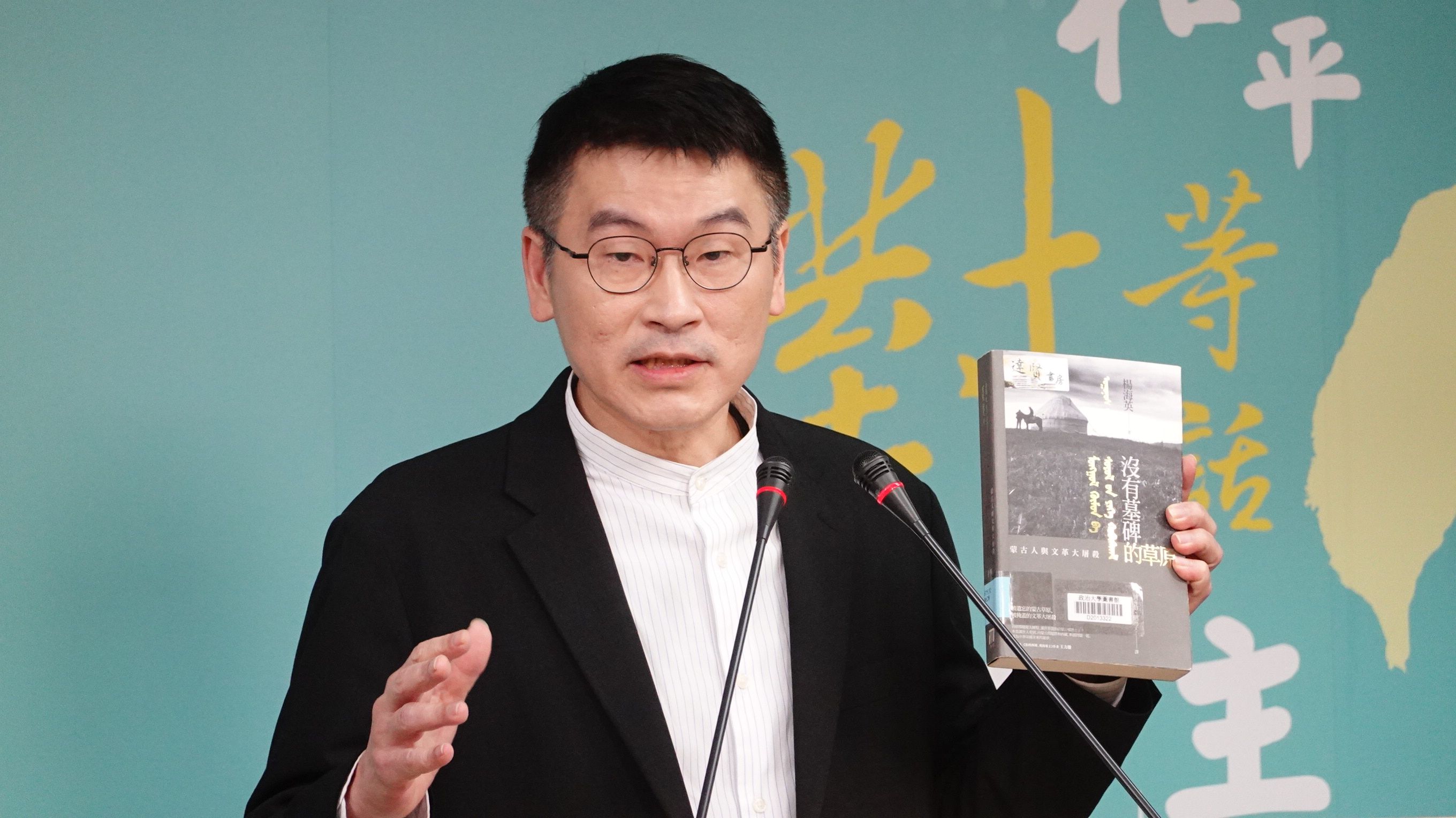 陸委會副主委拿出「八旗文化」總編輯富察出版的書籍《沒有墓碑的草原》，提醒各界留意大陸《民族團結進步促進法》可能帶來的制裁。（楊騰凱攝）