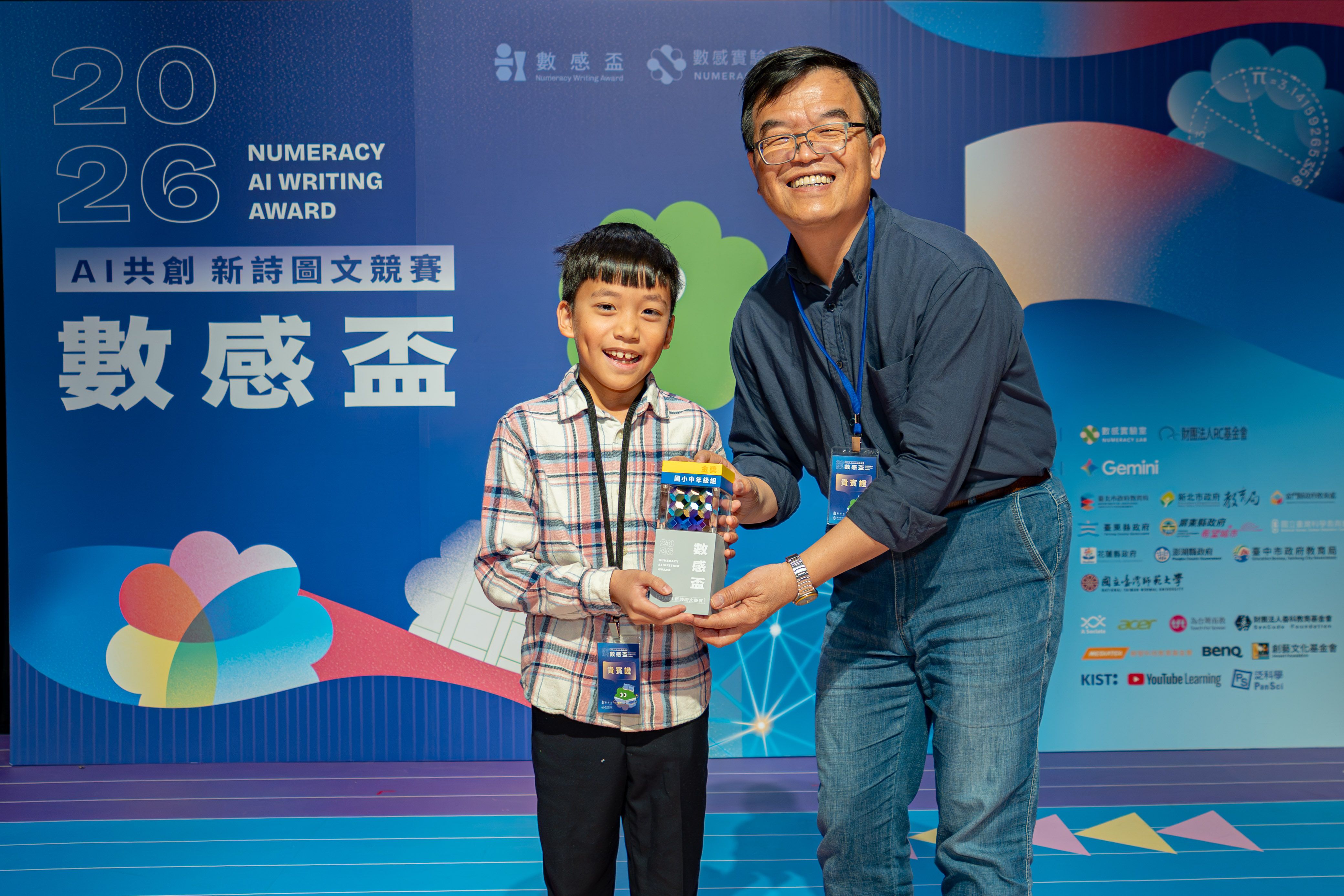 中年級組金獎得主、臺東縣東海國小學生林宥衡，其作品《回到幸福原點的飛行》靈感來自擔任飛行 員的爸爸，由兒童文學作家王文華頒發獎項。(主辦單位提供)