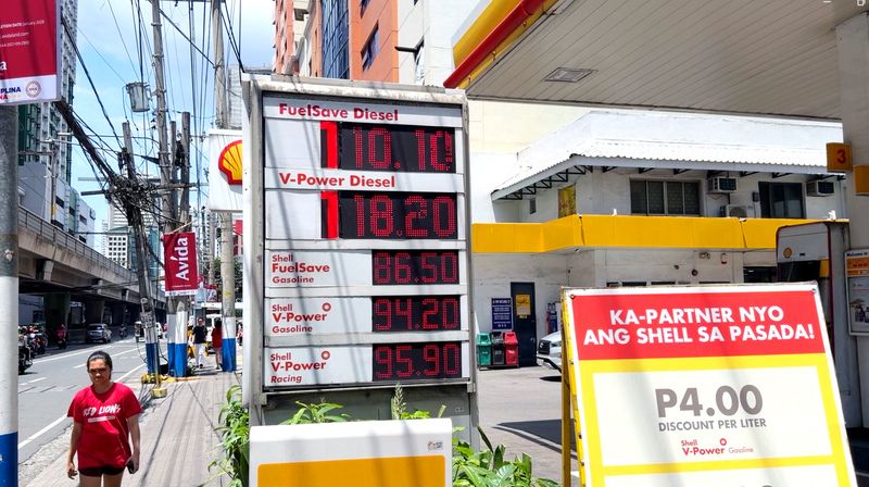 菲律賓油價飆漲　價格看板爆表 中東局勢升溫推升國際油價，導致菲律賓油價不斷飆新高。圖為馬尼拉市一座加油站的電子價格看板「爆表」，原先只設計到十位數，但因價格已破百，只好加貼寫有「1」字的紅色紙條。中央社記者林行健馬尼拉攝115年3月19日