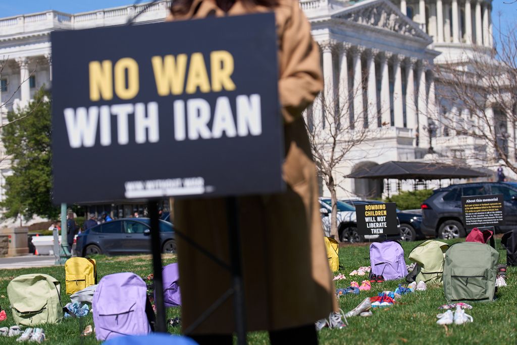 美國民眾高舉「不要和伊朗開戰」的抗議看板。（美聯社）