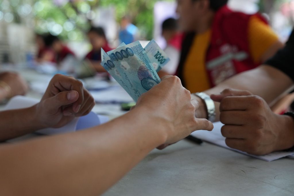 菲律賓計程車駕駛領取政府發放的燃料現金補貼。（美聯社）
