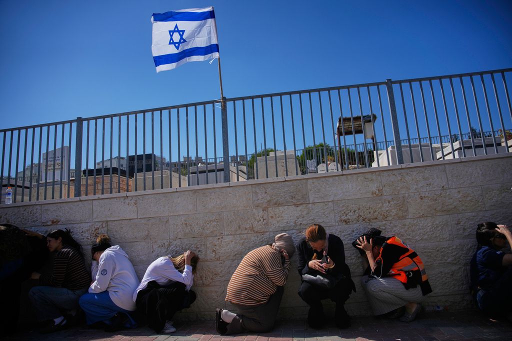 以色列民眾在空襲警報發布後就地躲避。（美聯社）