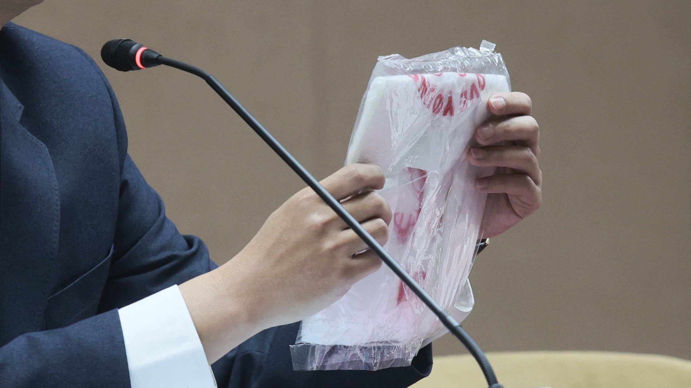 台湾・経済部が4日に開催した「原油価格調整結果および中東情勢を受けたエネルギー・石化製品の安定供給対策」記者会見にて、担当官がプラスチック袋を手に持ち供給状況を説明した。（柯承恵氏撮影）