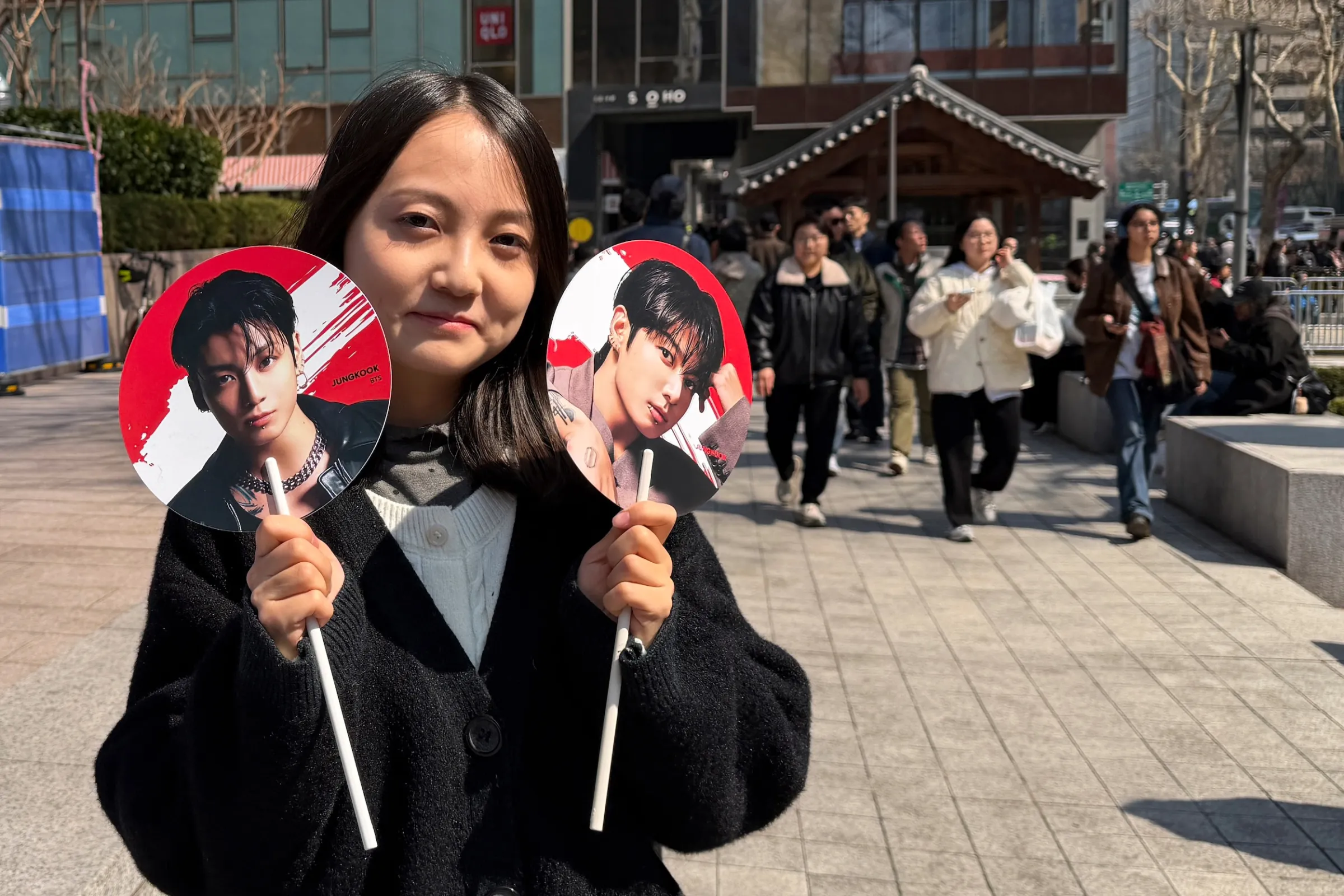 2026年3月21日，在韓國首爾光化門廣場附近，BTS回歸演唱會前夕，來自甘肅的中國BTS粉絲手持週邊商品拍照留念。（美聯社）