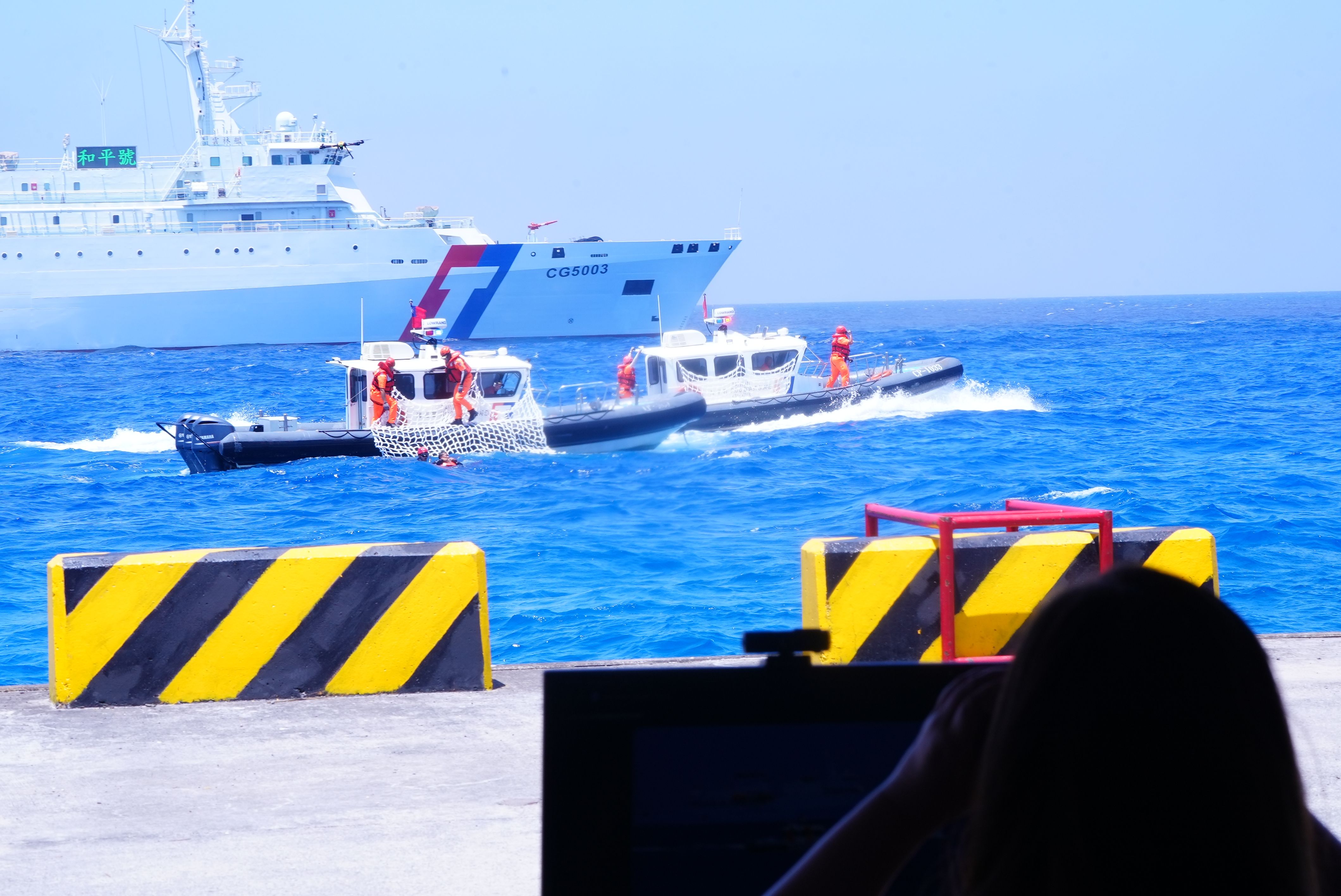 20260422-海巡署於南沙太平島海域實施「南援九號」人道救援、醫療後送及海洋除污聯合演練。沿岸多功能艇釋放救生攀爬網。（海巡署提供）