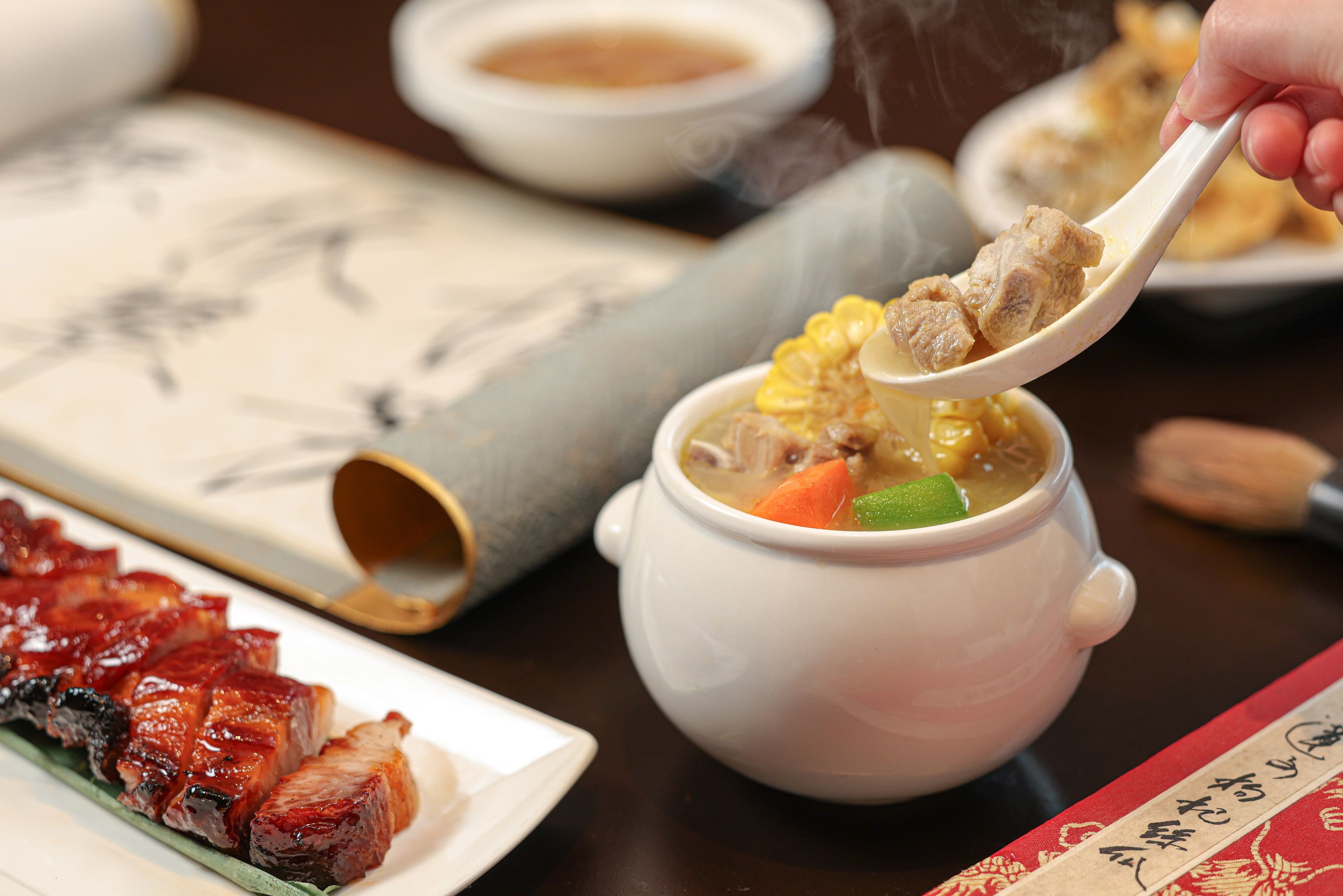  由故宮晶華推出的「晶華好味道」晚間套餐中，開胃前菜匯集晶華軒招牌的蜜汁叉燒、玫瑰油雞、黃金炸魚皮等選項，湯品則備有足料老火靚湯與瑤柱花膠銀耳羹，為饕客滋補暖胃。（圖/故宮晶華）