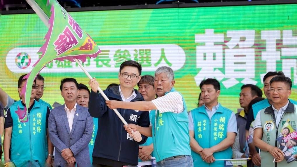 立委賴瑞隆為小港後援會長洪進國進行授旗儀式，眾人齊聲高喊口號，展現團結拚勝選的強大氣勢。（圖/徐炳文攝）