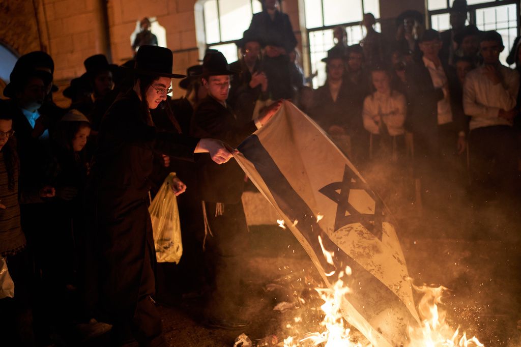 一群正統派猶太人在以色列獨立日焚燒以色列國旗表達抗議。（美聯社）