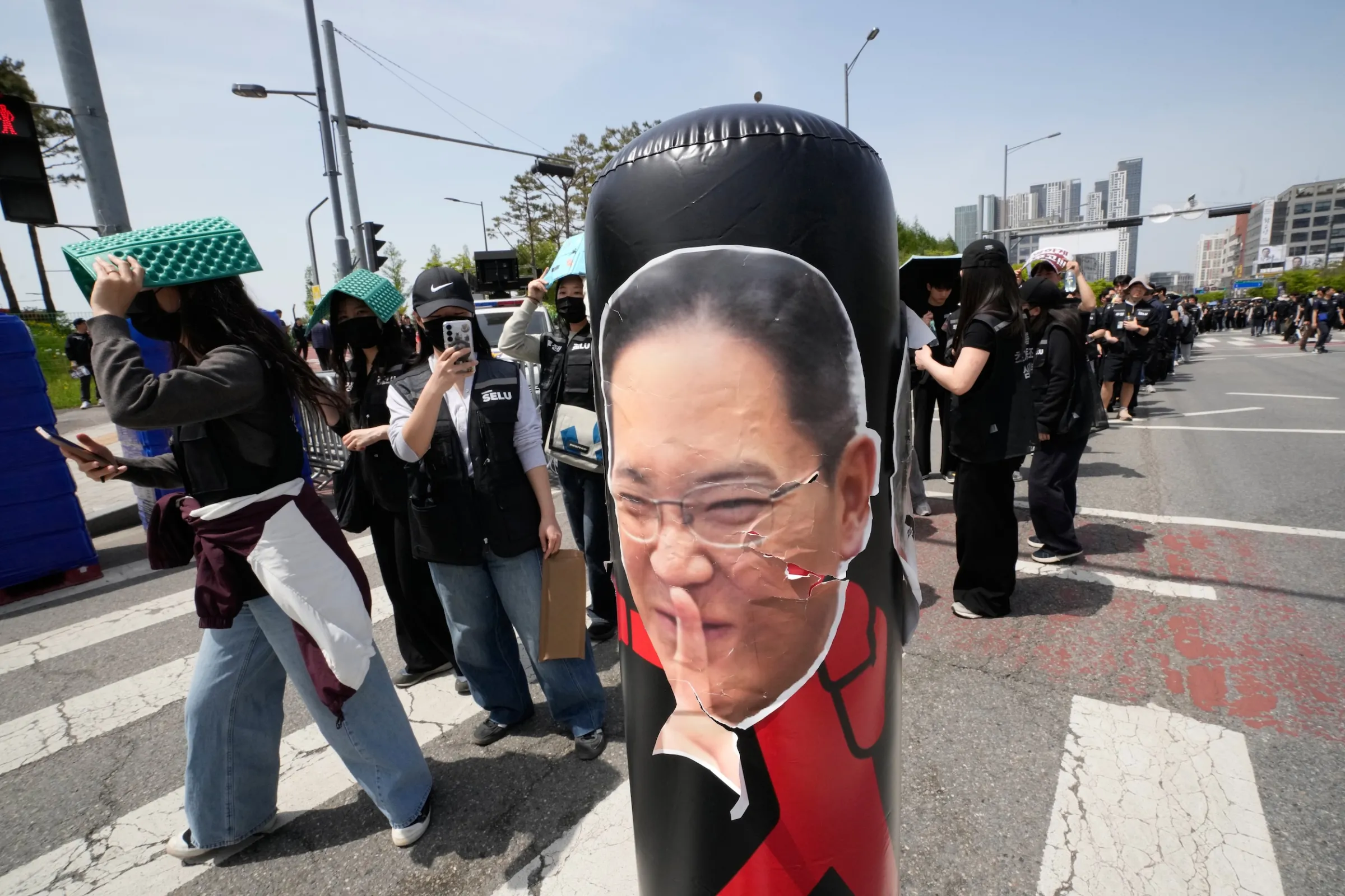 2026年4月23日,韓國平澤市的三星電子晶片工廠發起抗爭、要求提高獎金,三星電子董事長李在鎔的照片也成為抗議道具。(美聯社)