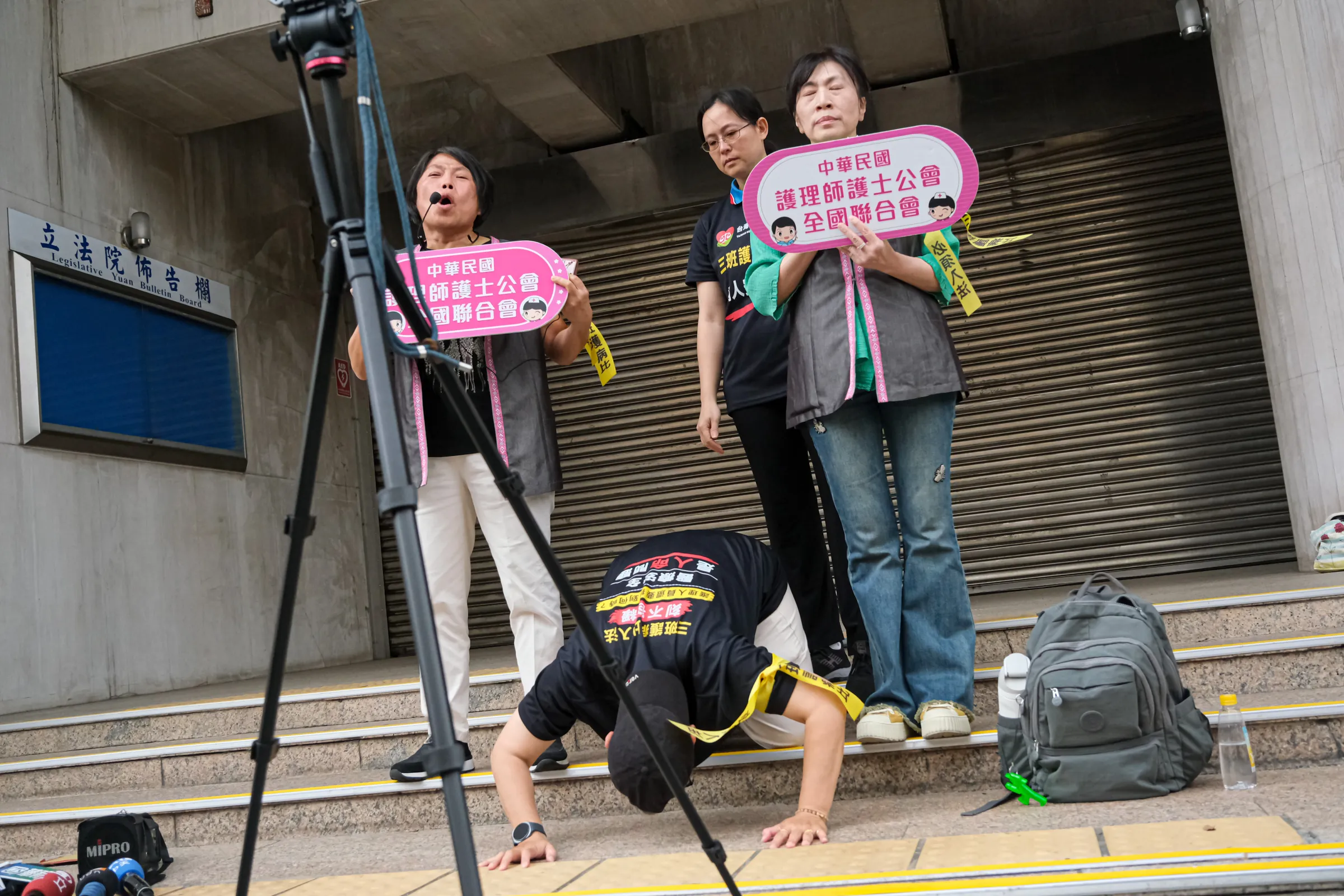 20260508-台灣護師醫療產業工會顧問陳玉鳳（中）、中華民國護理師護士公會全國聯合會理事長陳麗琴（右）、副理事長馬淑清（左）8日於立法院群賢樓外集合抗議，要求三班護病比入法醫療法修法諮詢委員會，並堅持二分之一不能退，病人安全照護由護理人員決定。（劉偉宏攝）
