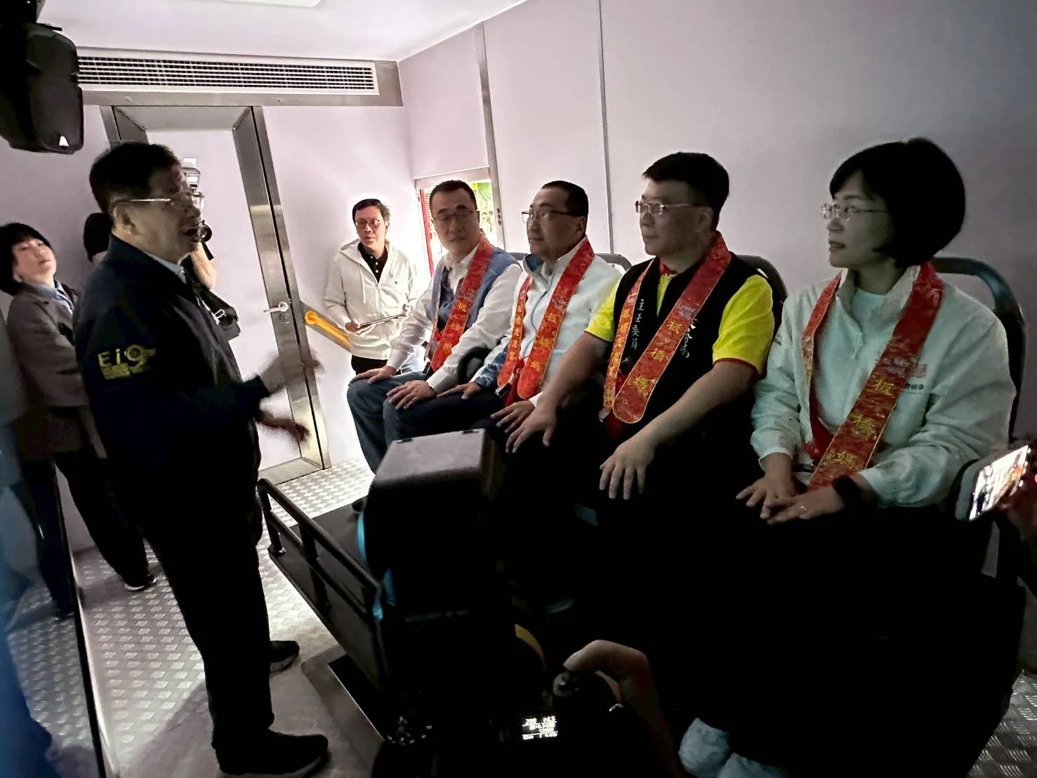 新北市政府消防局局長陳崇岳向慈惠宮主委賴春穆、侯友宜市長、市長候選人李四川副市長及市長候選人蘇巧慧立法委員說明最新型地震體驗車功能（圖/新北市政府消防局）