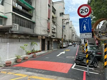 新店中正路117巷行人優先區入口壓花瀝青鋪面及優先區、20公里速限標誌。（圖／新北市政府交通局提供）