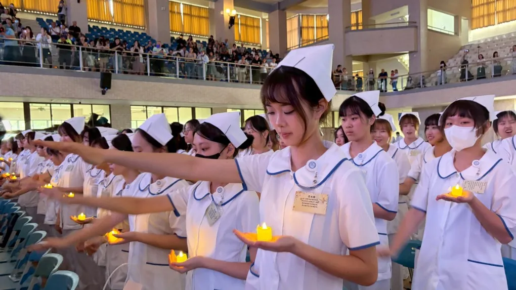 護理系準白衣天使高舉燭光，齊聲宣讀南丁格爾誓詞。（圖/輔英科大提供）