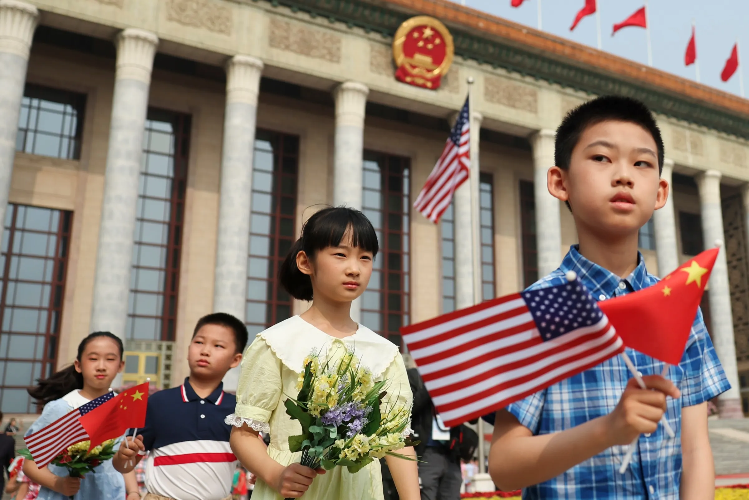 2026年5月14日，中國小孩在川習會歡迎儀式開始前，在人民大會堂前揮舞國旗。（美聯社）
