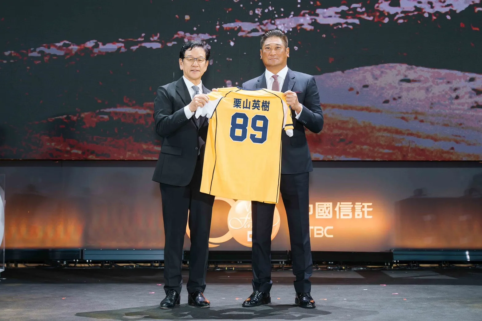 20260517－中信慈善基金會董事長辜仲諒（右）致贈中信兄弟紀念球衣予日本職棒北海道日本火腿鬥士隊首席棒球總管栗山英樹（左）。（中信金提供）