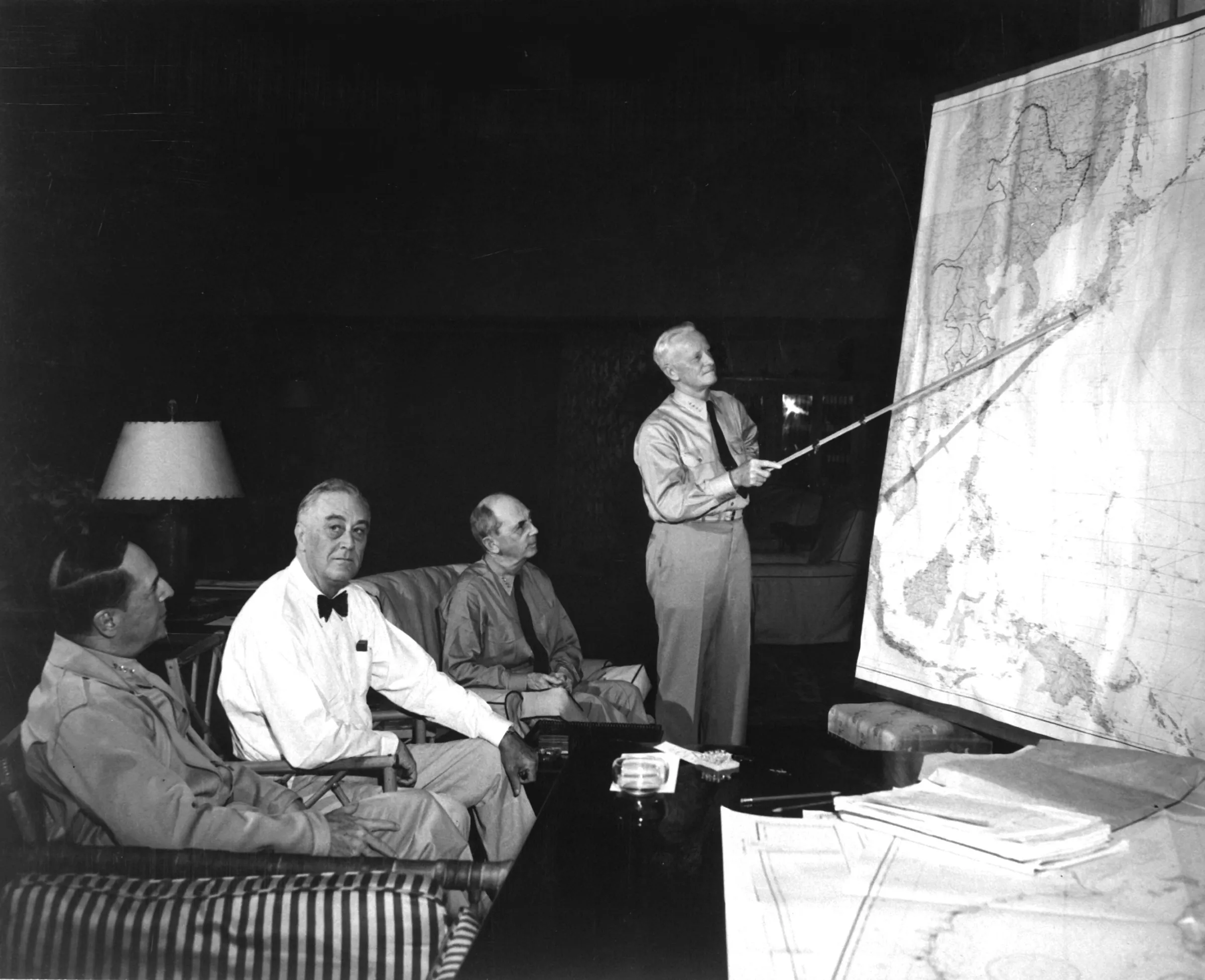 1944年'7月,美國高層在夏威夷商討接下來的對日作戰方向,站立者為美國海軍將領尼米茲,左一為麥克阿瑟,左二為羅斯福總統。(維基百科)