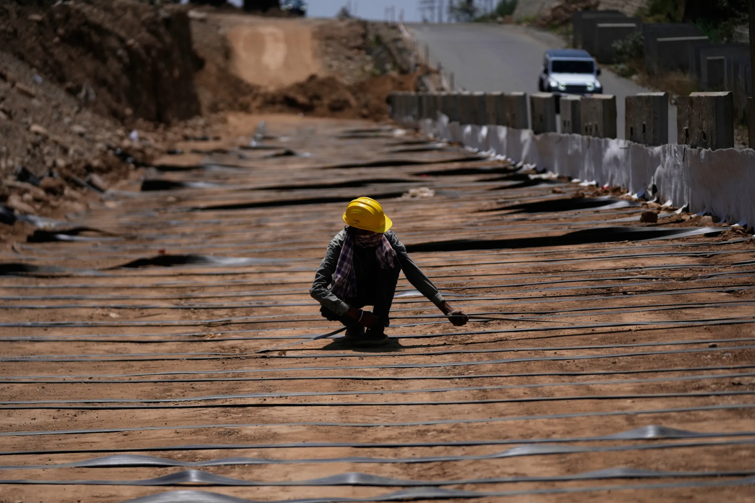 2026年5月16日，印度查謨郊區，一名工人在炎熱的天氣裡進行高速公路施工。（美聯社）